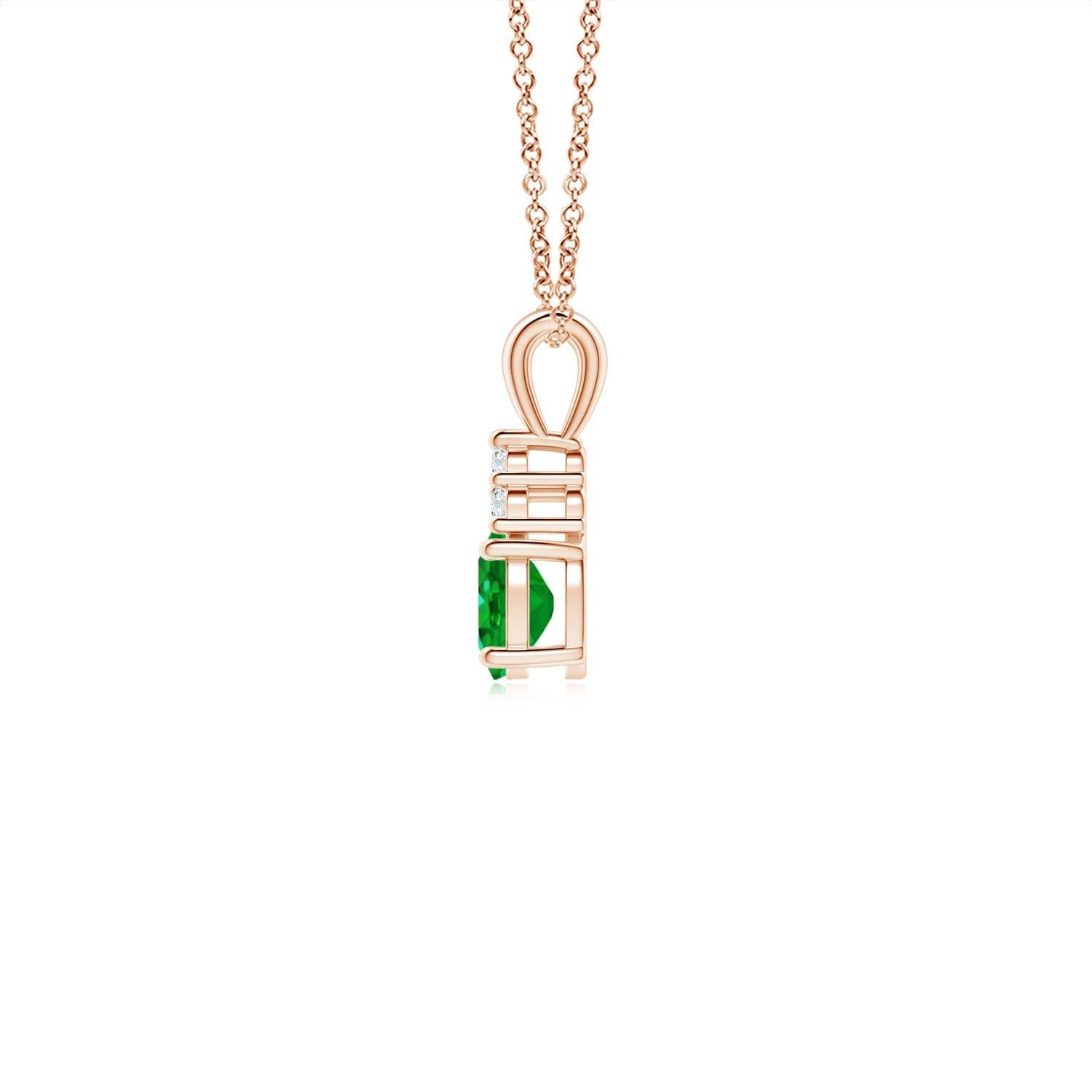 Serti dans de l'or rose 14k, ce pendentif solitaire classique en émeraude présente un mélange parfait de style et d'élégance. Il est orné d'une émeraude verte luxuriante et de trois diamants ronds étincelants sur le dessus. Relié à un anneau en V