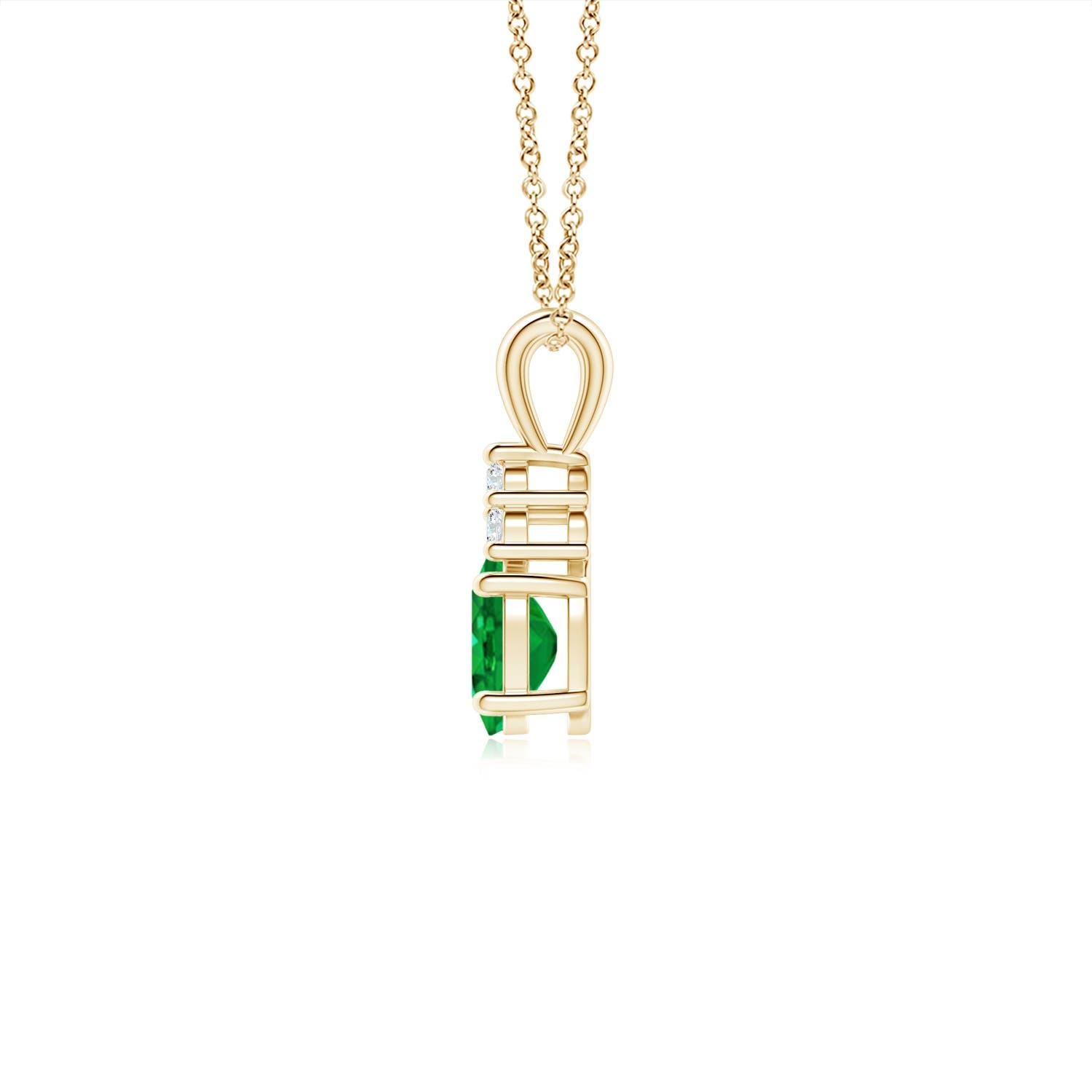 Engarzado en oro amarillo de 14 quilates, este clásico colgante solitario de esmeralda muestra la mezcla perfecta de estilo y elegancia. Presenta una exuberante esmeralda verde adornada con tres brillantes diamantes redondos en la parte superior.