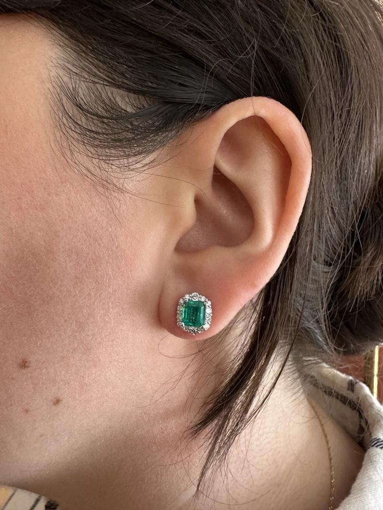 Clous d'oreilles avec halo de diamants en platine et or blanc 18 carats

Les boucles d'oreilles en émeraude naturelle et diamant présentent deux émeraudes naturelles pesant 2,31 carats au total, entourées d'un halo de diamants ronds de taille