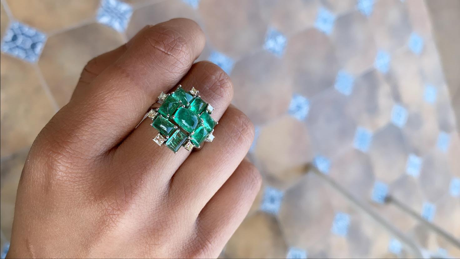 A modern and chic , uniquely designed natural emerald and diamond ring set in 18k white gold. The emerald weight is 5.95 carats and diamond weight is .40 carats. The net gold weight is 7.16 grams and ring dimensions in cm 2 x 2 x 2.6 (LXWXH). US