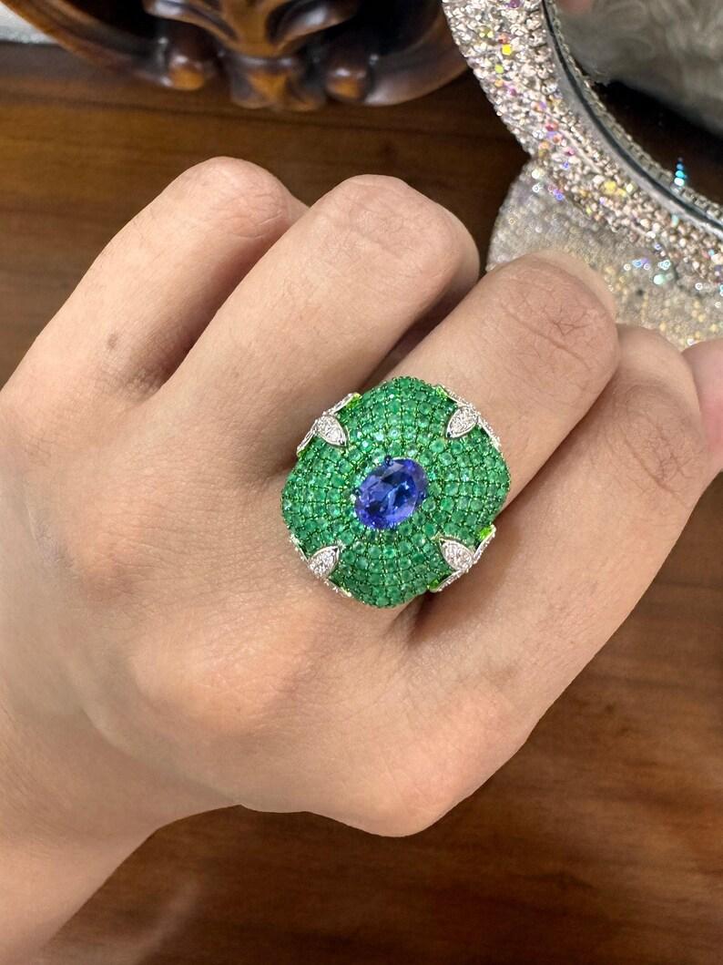 PRODUCT DETAILS -

===============

GEMSTONE DETAILS :

Gemstone : Emerald, Tanzanite

Gemstone Weight : 1.03 Cts., 0.86 Cts

Gemstone Size : Mix, 7X5 MM

Gemstone Shape : Round Cut, Oval Cut

Gemstone Type : Natural



DIAMOND DETAILS :

Diamond
