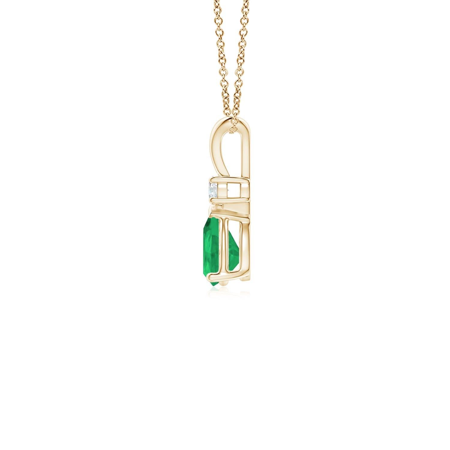 Ce pendentif solitaire classique est orné d'une émeraude en forme de poire, fixée dans un serti clos. Un diamant rond brillant est posé sur la pierre précieuse d'un vert luxuriant, ce qui ajoute à la beauté du design. Simple mais séduisant, ce