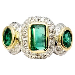 Natural Emerald Three Stone Ring with Pave Diamond Halos in 18 Karat Gold
