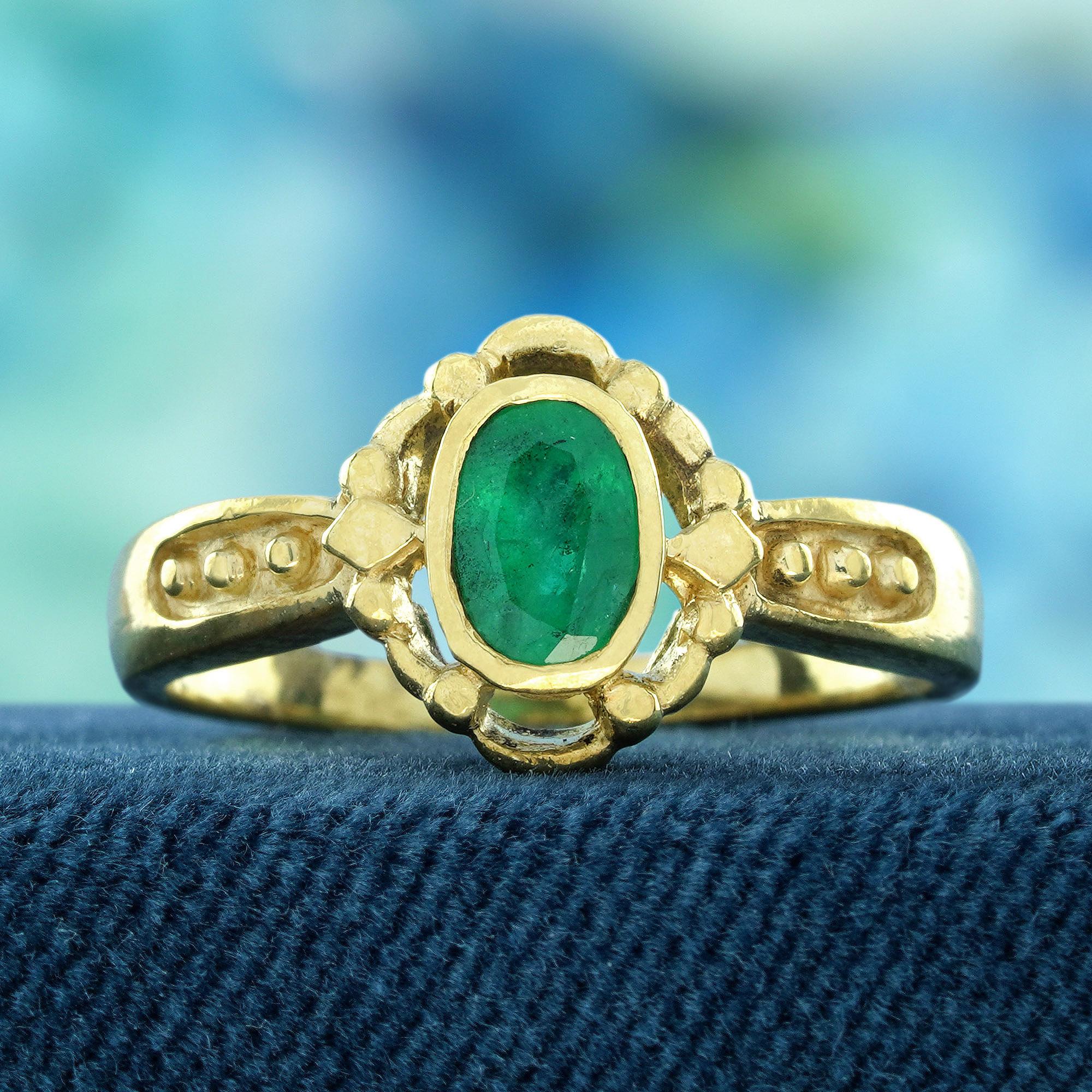 Découvrez le savoir-faire exquis de notre bague de fiançailles en or jaune 9 carats, de style vintage et ornée d'une émeraude naturelle. Cette superbe pièce présente une émeraude ovale sertie d'un chaton, réputée pour sa riche teinte verte et sa