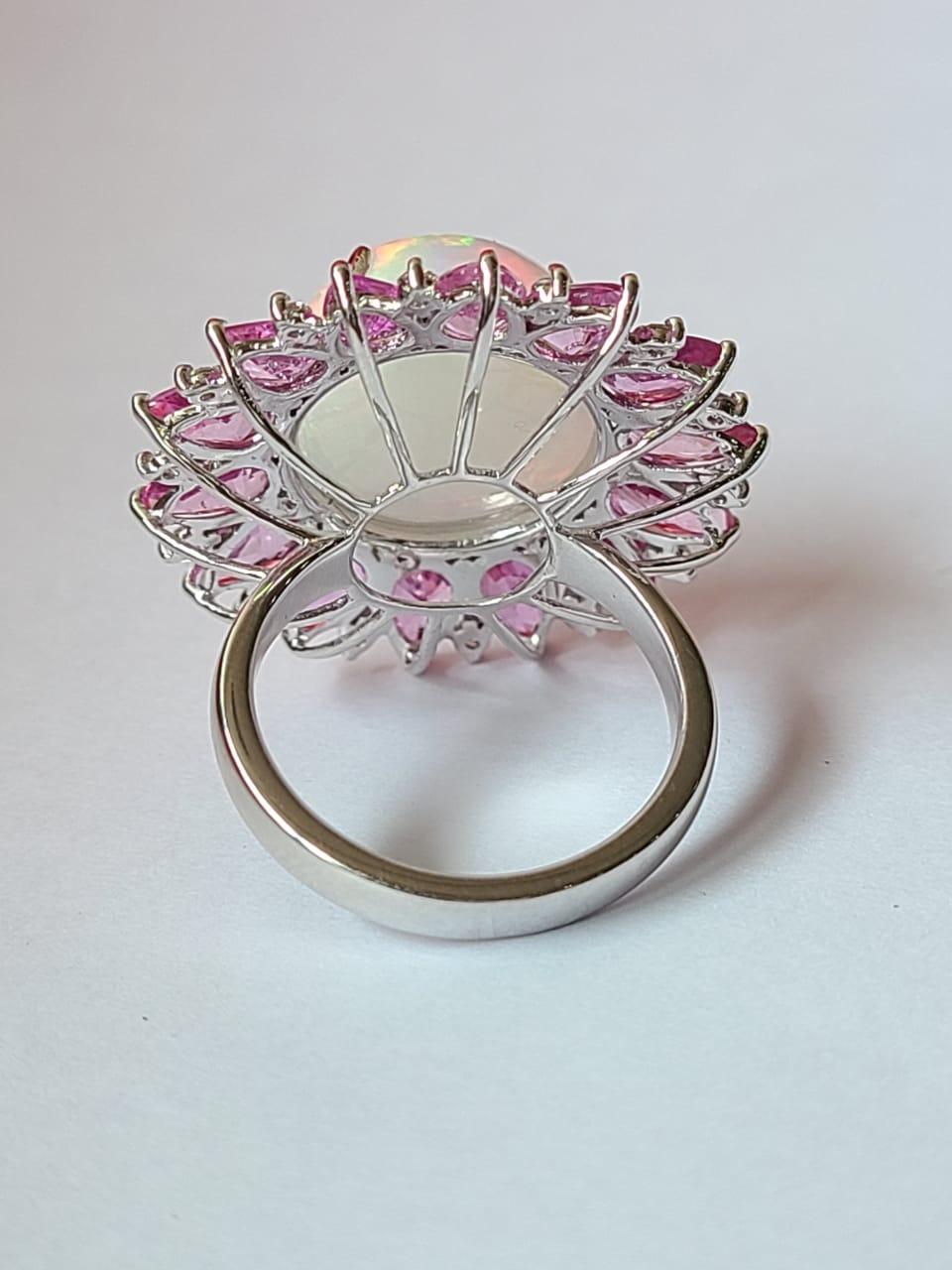 A very gorgeous and one of a kind, Opal & Pink Sapphire Cocktail Ring set in 18K Gold & Diamonds. The weight of the Opal is 9.08 carats. The Opal is of Ethiopian origin and has a gorgeous play of colour. The weight of the Pink Sapphires is 6.46