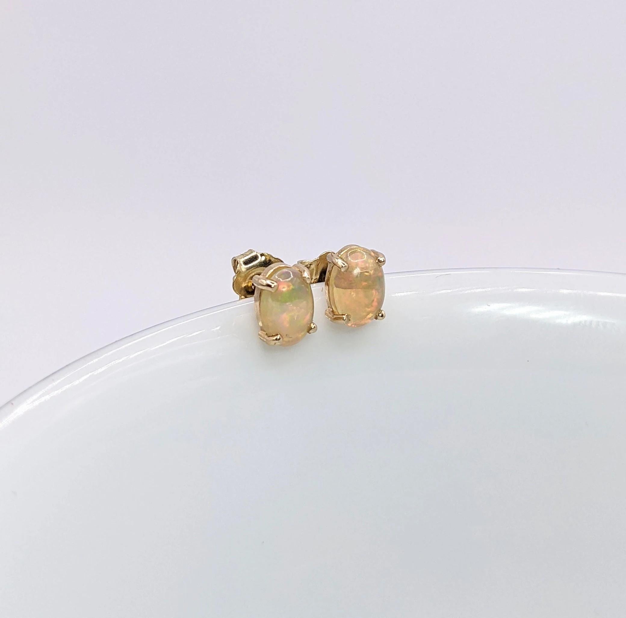 Ces magnifiques boucles d'oreilles en or massif 14 carats sont ornées de pierres centrales ovales en opale éthiopien de 7 x 5 mm, créant un look amusant et ardent. Un design de boucle d'oreille solitaire parfait pour des fiançailles ou un