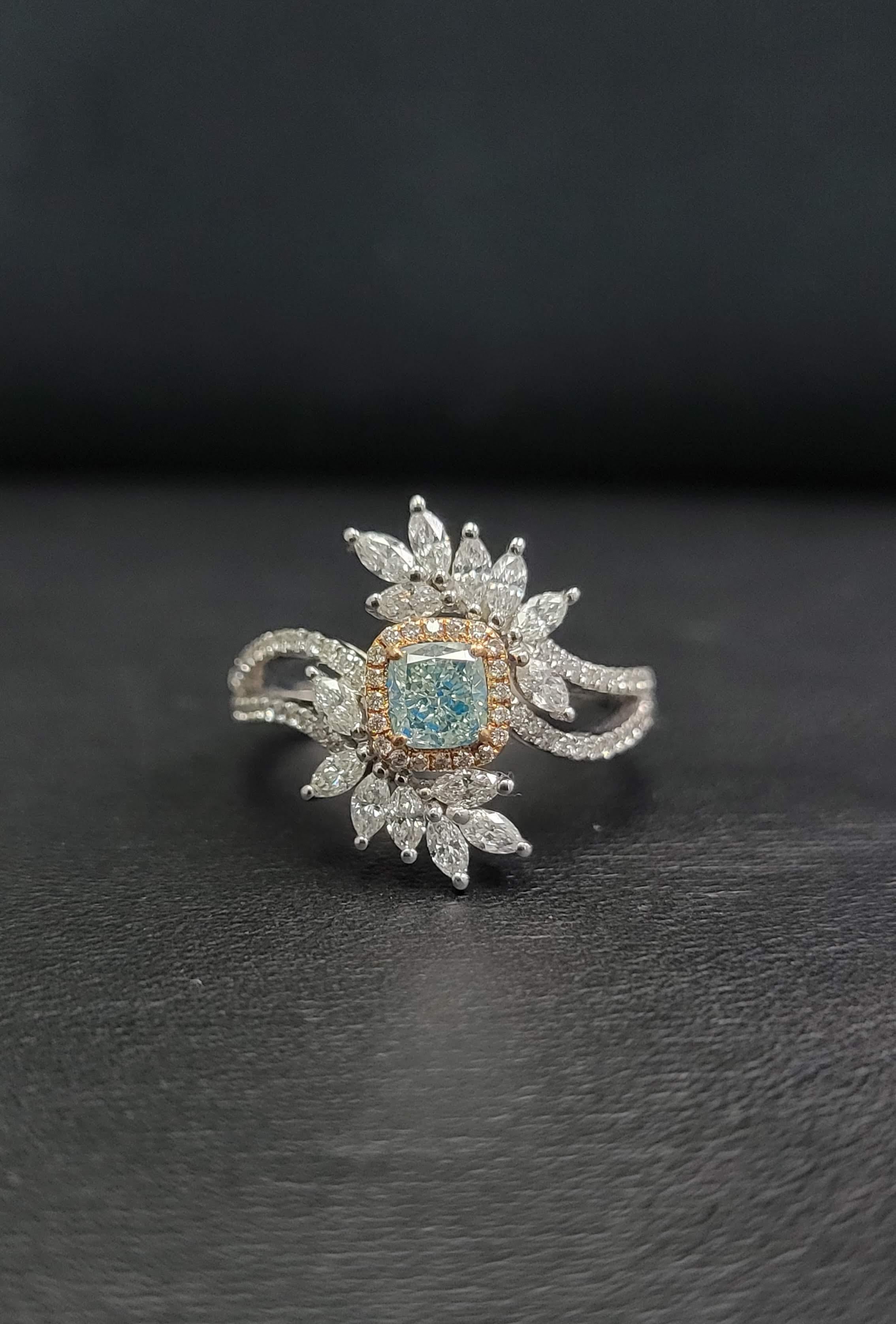 This ring features a beautiful blue diamond as the center stone weighing approx. 0.42cts. Encircling the gorgeous gem is a beautiful halo of glimmering white diamonds. The outer borders display an array of 14 pear shaped diamonds as well as accent