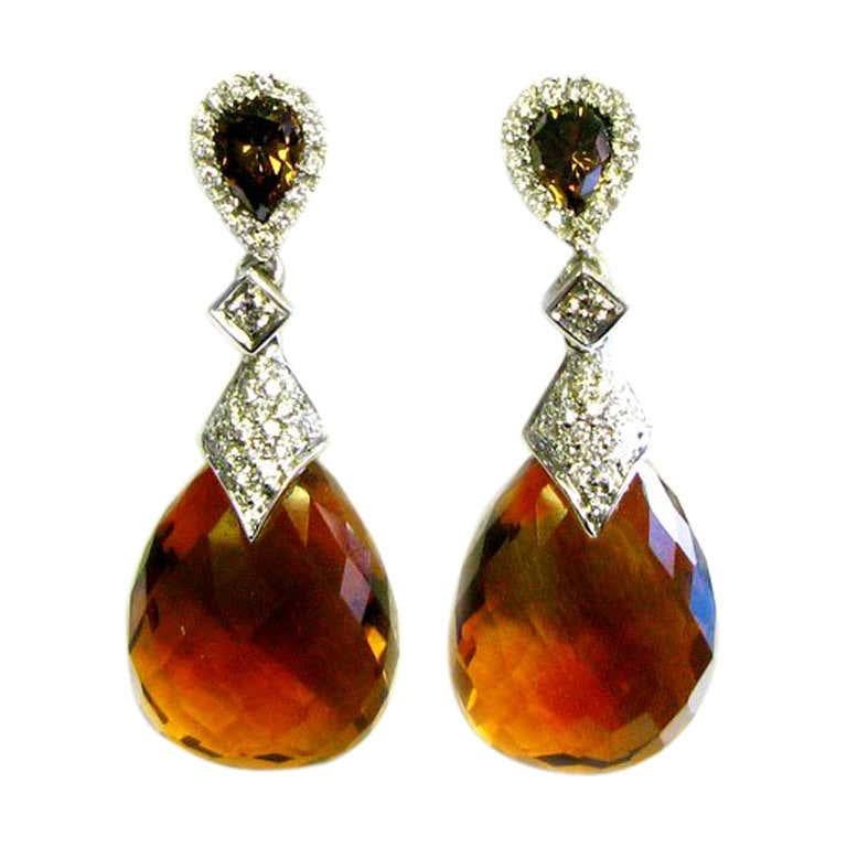 Brown is the color of the season and these earrings are no exception! These gorgeous drop earrings feature natural fancy brown pear-shaped diamonds with a white pave frame, as well as a beautiful pear citrine, all set in 18K white gold. They will go