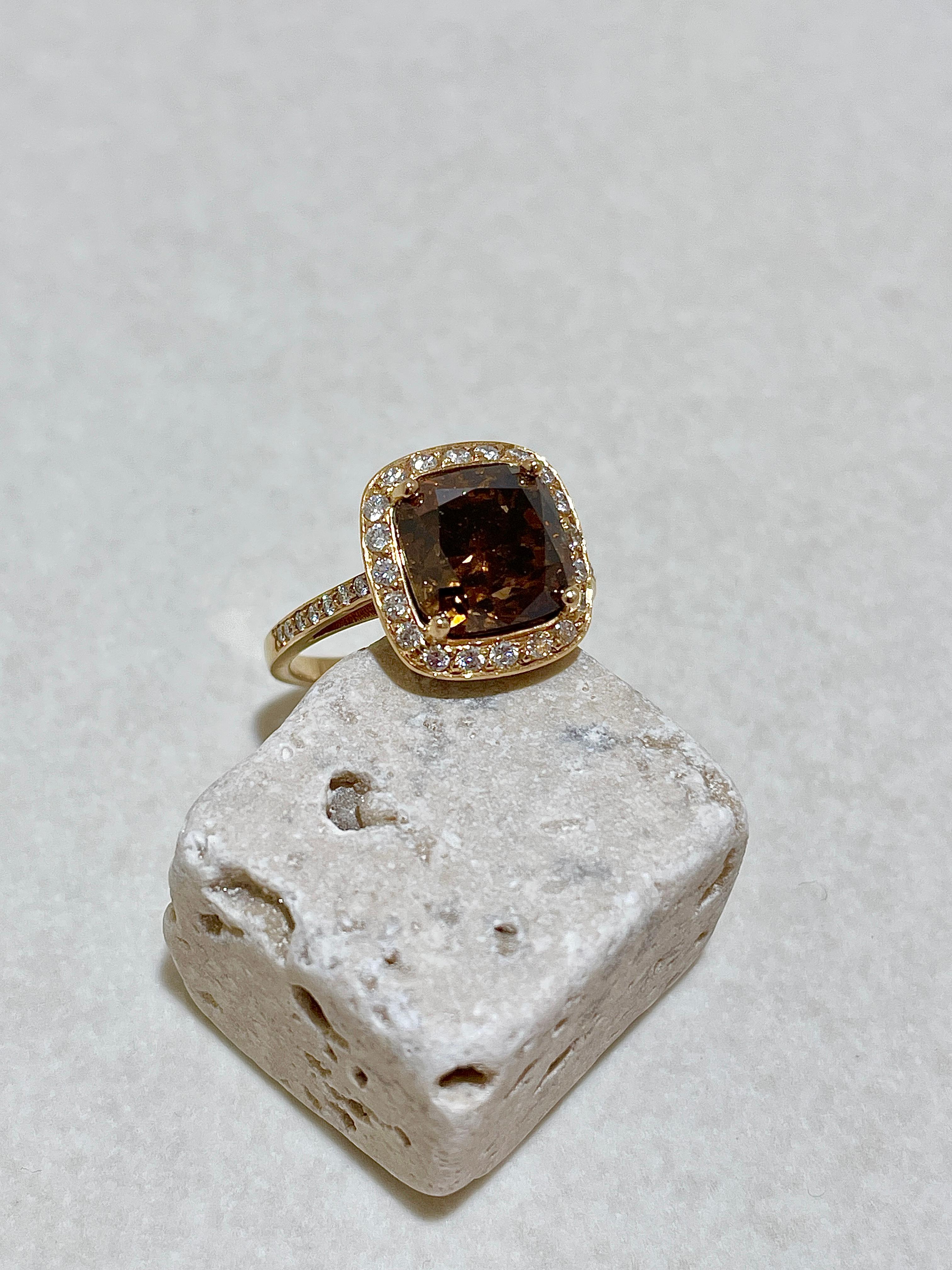 Der Ring aus 18kt Gelbgold mit einem unbehandeltem Braunen Diamanten im Kissenschliff hat 5,5 Karat und wird mit einem IGI Zertifikat geliefert. Umrandet ist der Braune Diamant mit insgesamt 35 weißen Brillanten 0,41ct TW/si. Die Karat des Braunen