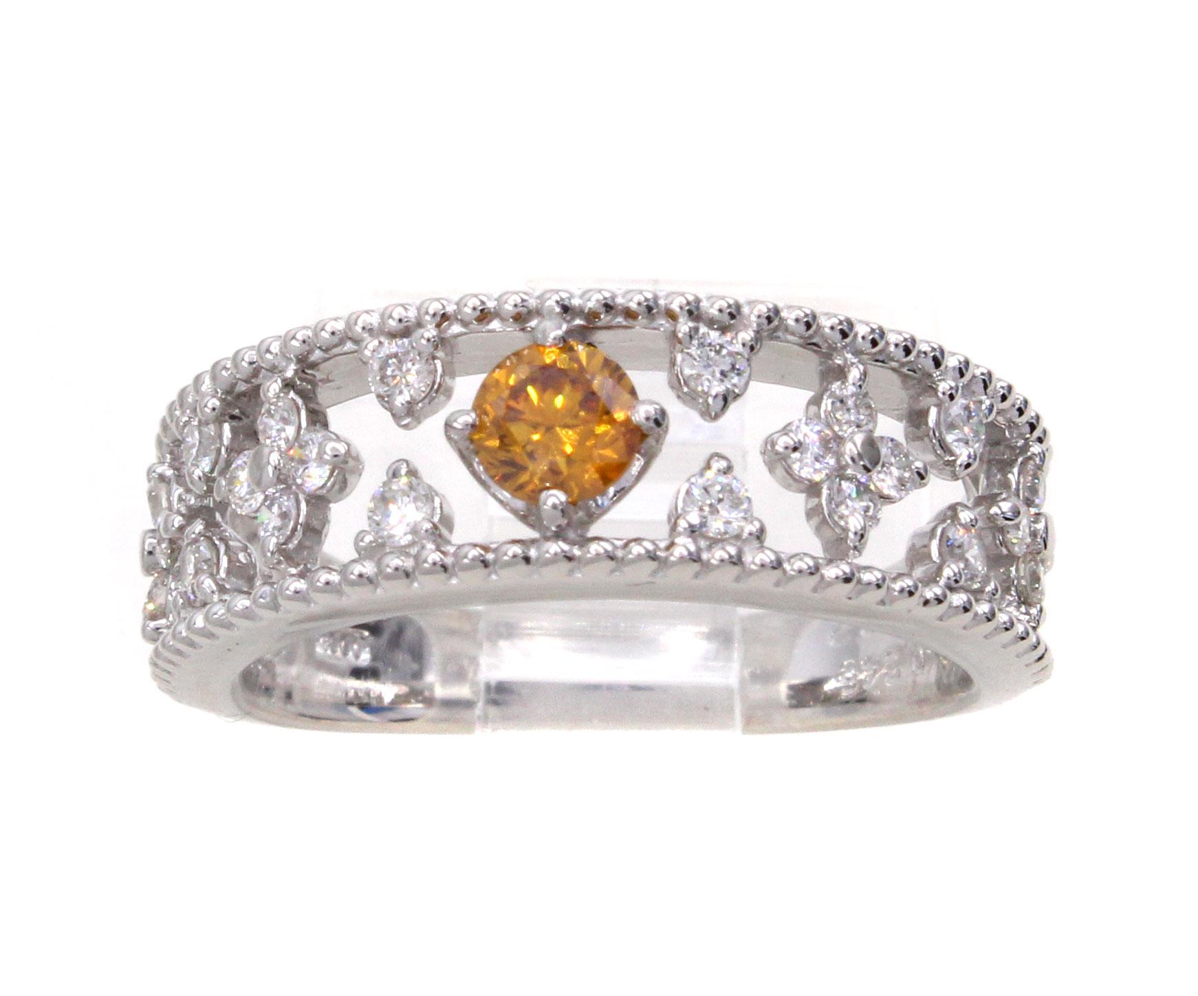 A vibrant bright orange brilliant cut diamond weighing 0.24 carats is the center piece of this lovely platinum eternity band. Accompanied by a report from the GIA the color is graded as natural fancy deep yellow-orange. The extremely well