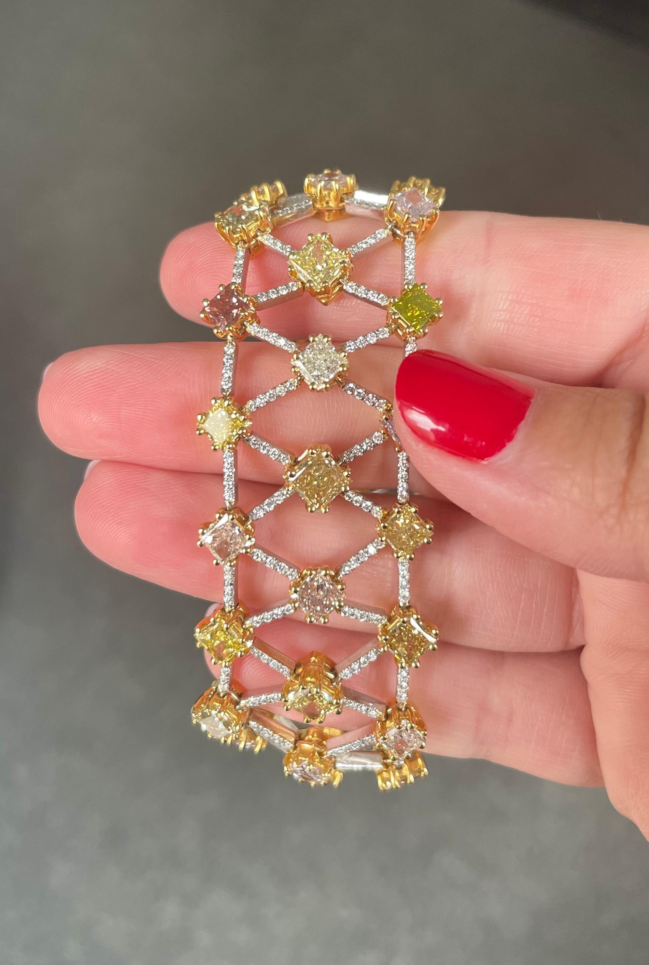This exceptional celebration of color is truly a one of a kind piece! This gorgeous bracelet is a rainbow of yellow, green, pink, and orange fancy colored diamonds. The diamonds are set in 18K yellow gold, which is a beautiful complement to the