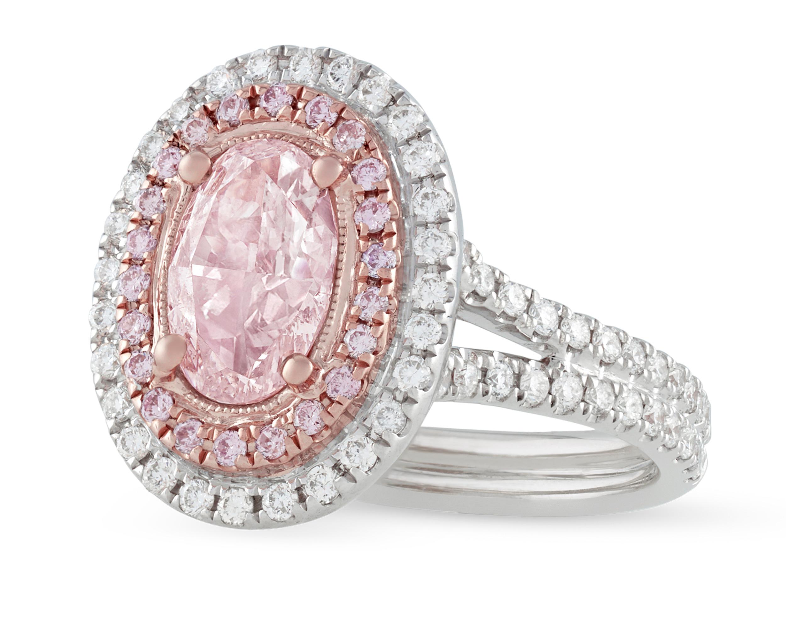 Displaying a delicate, even coloration is the beautiful natural fancy light pink diamond in this ring. Certified by the Gemological Institute of America to be natural fancy light brown-pink, this fabulous 1.30-carat diamond is surrounded by a halo