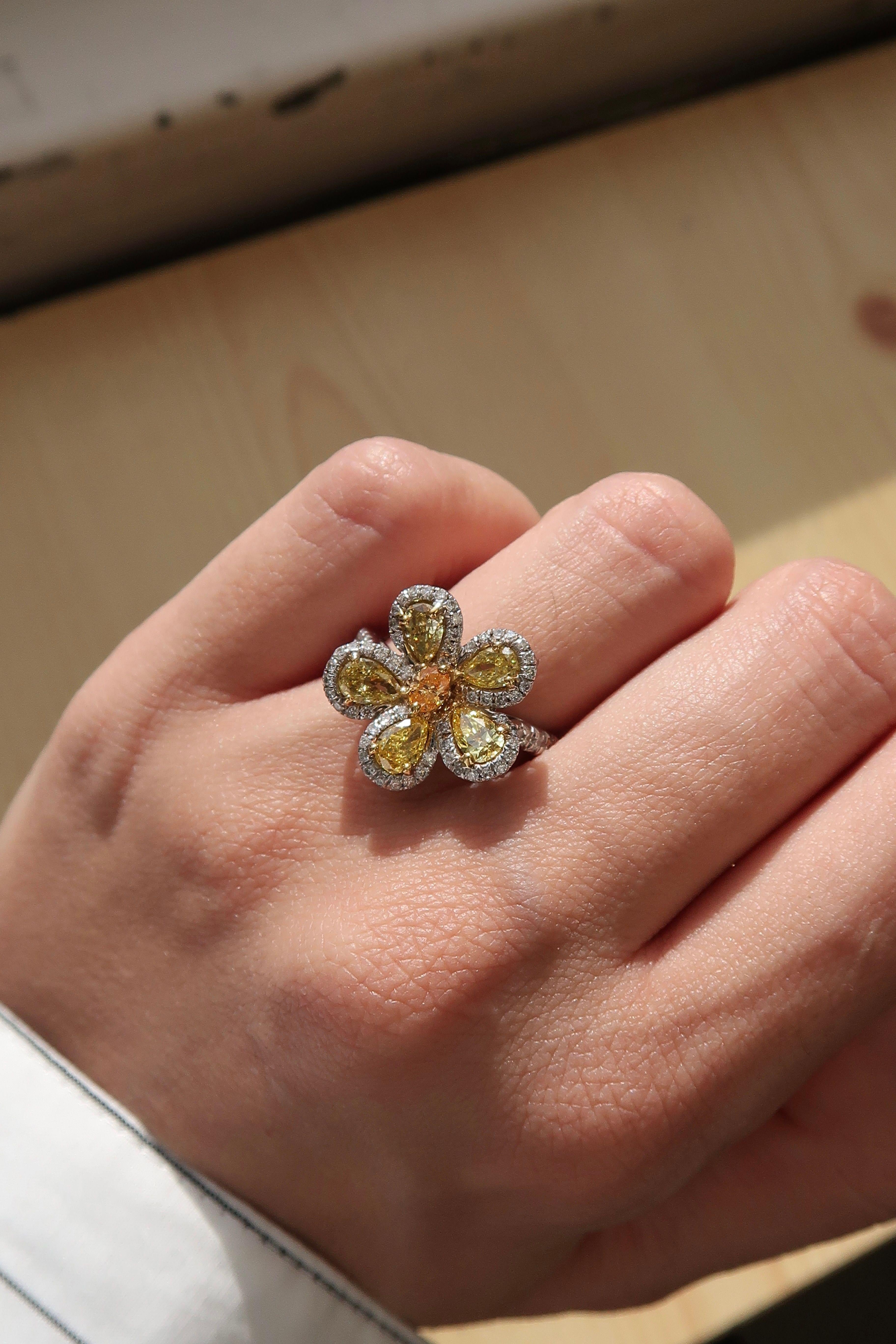 Bague de cocktail en or 18k avec fleur et motif en diamant de couleur naturelle jaune et orange.
Cinq diamants jaunes fantaisie en forme de poire parfaitement assortis, totalisant 1,08 carat, forment les élégants pétales de la fleur. Chaque diamant