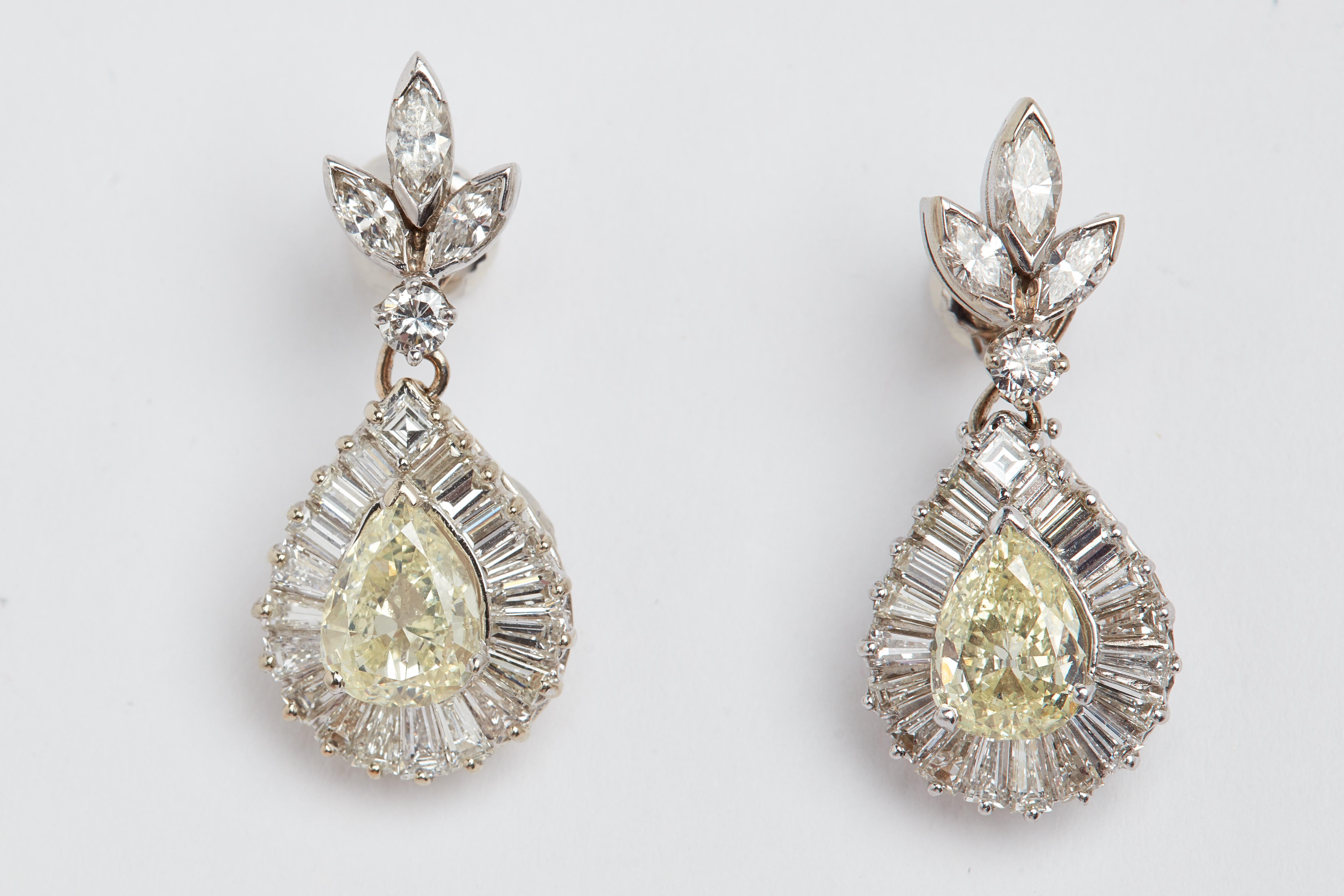 18k White Gold Natural Fancy Yellow and White Diamond Earrings. 2 pear shape center stones weight approximately 2.31 carats total weight. All white diamonds approximately 4.50 carats total weight. 