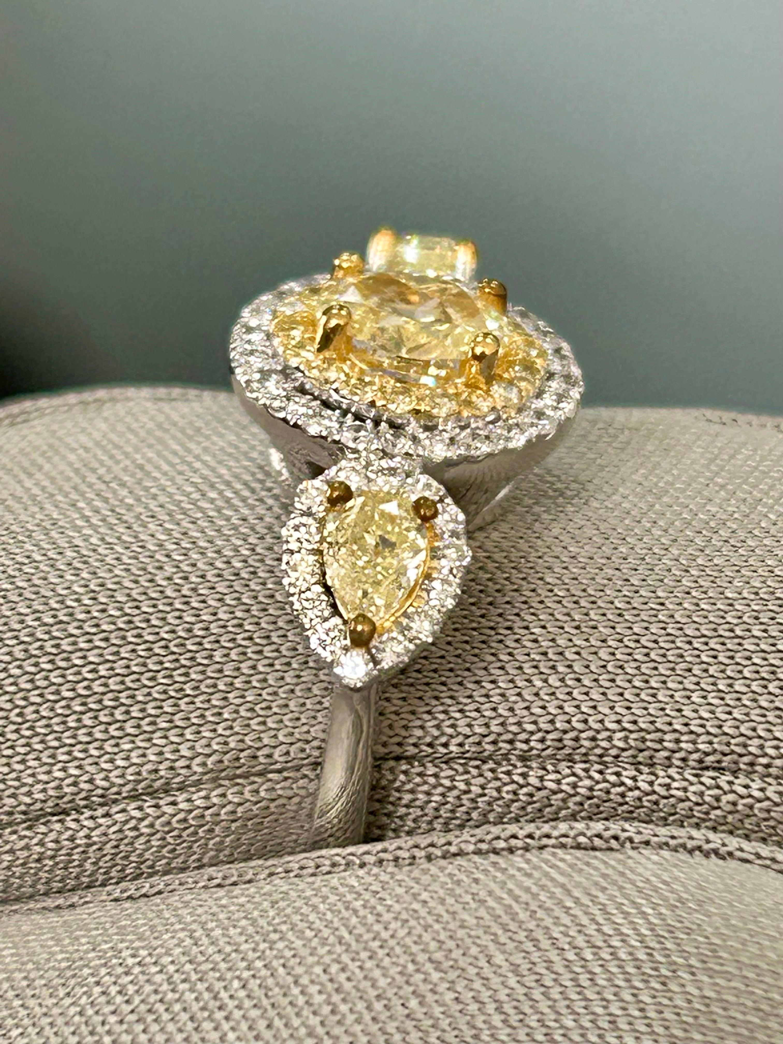 This is a Luscious Lemons™️ Natural Fancy Yellow Diamond 3 stone Oval ring with Pear side stones and white melee halo. The ring size is 6.5 and is in 14k WG/YG. 1.20 cts total. Yellow Oval Center = 0.50 cts Fancy Yellow VS clarity. Yellow Pear sides