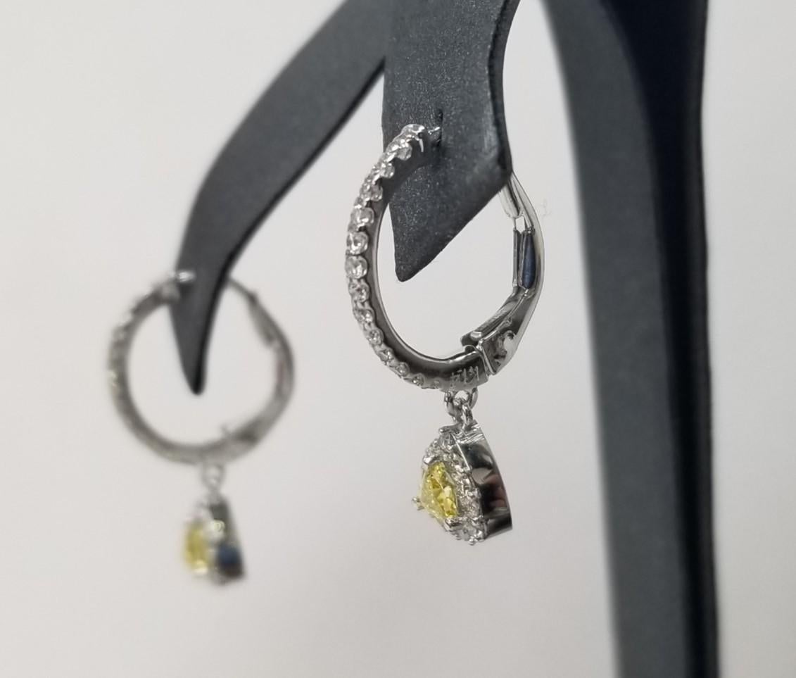 About
14k white gold 
5/8 inch in diameter diamond hoop earrings
Specifications:
    main stones: 2 Natural Fancy Yellow Trillion Cut Diamonds
    side stone: 50 round Diamonds    
    carat total weight: .45Pts.
    color: G
    clarity: VS
   