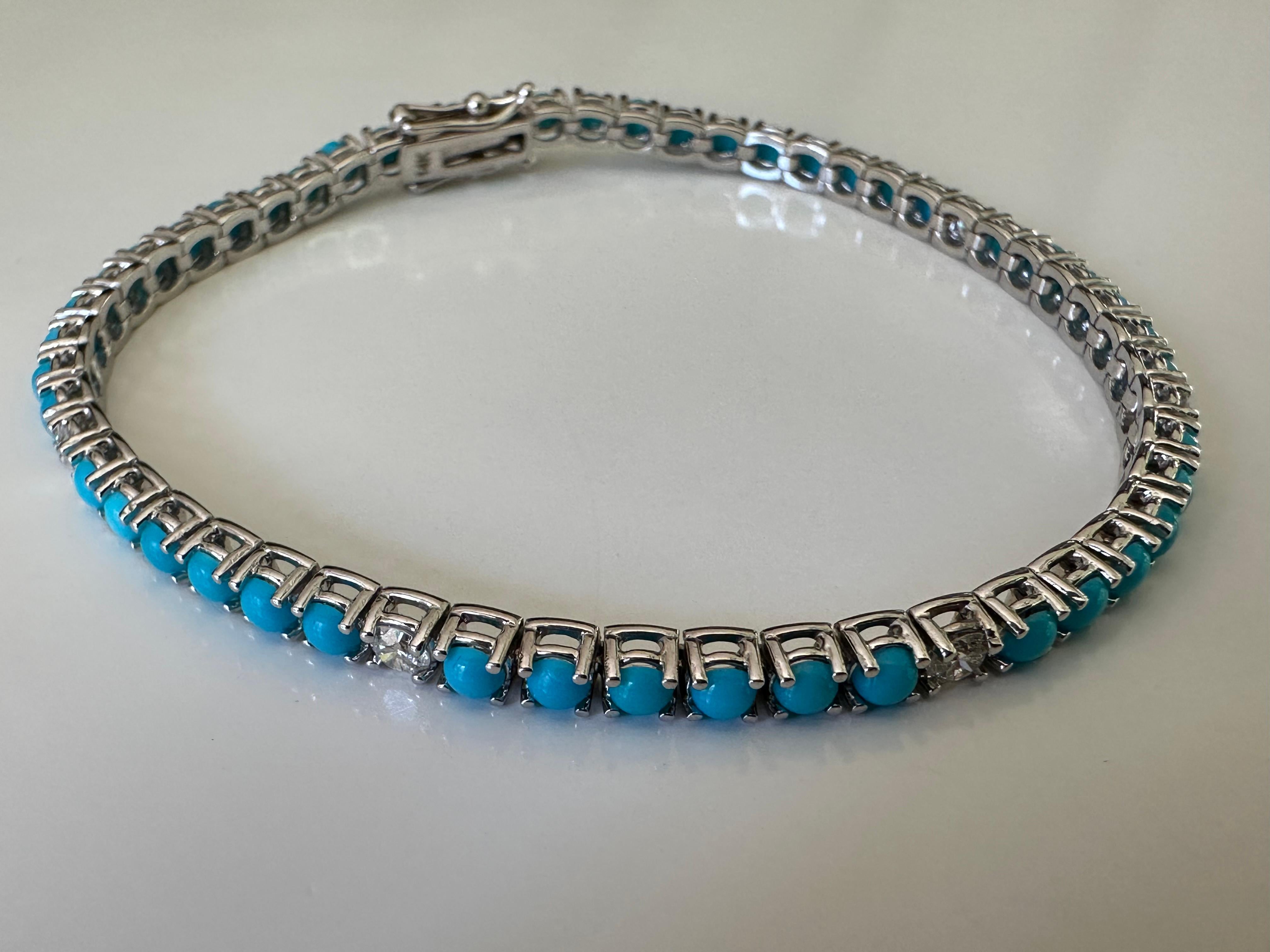 This exquisite tennis bracelet set in 14K white gold features forty-eight natural fine turquoise round-shaped cabochons-- all hand cut to match-- interspersed with five natural white round diamonds totaling 0.50 carats, G color, VS clarity, to