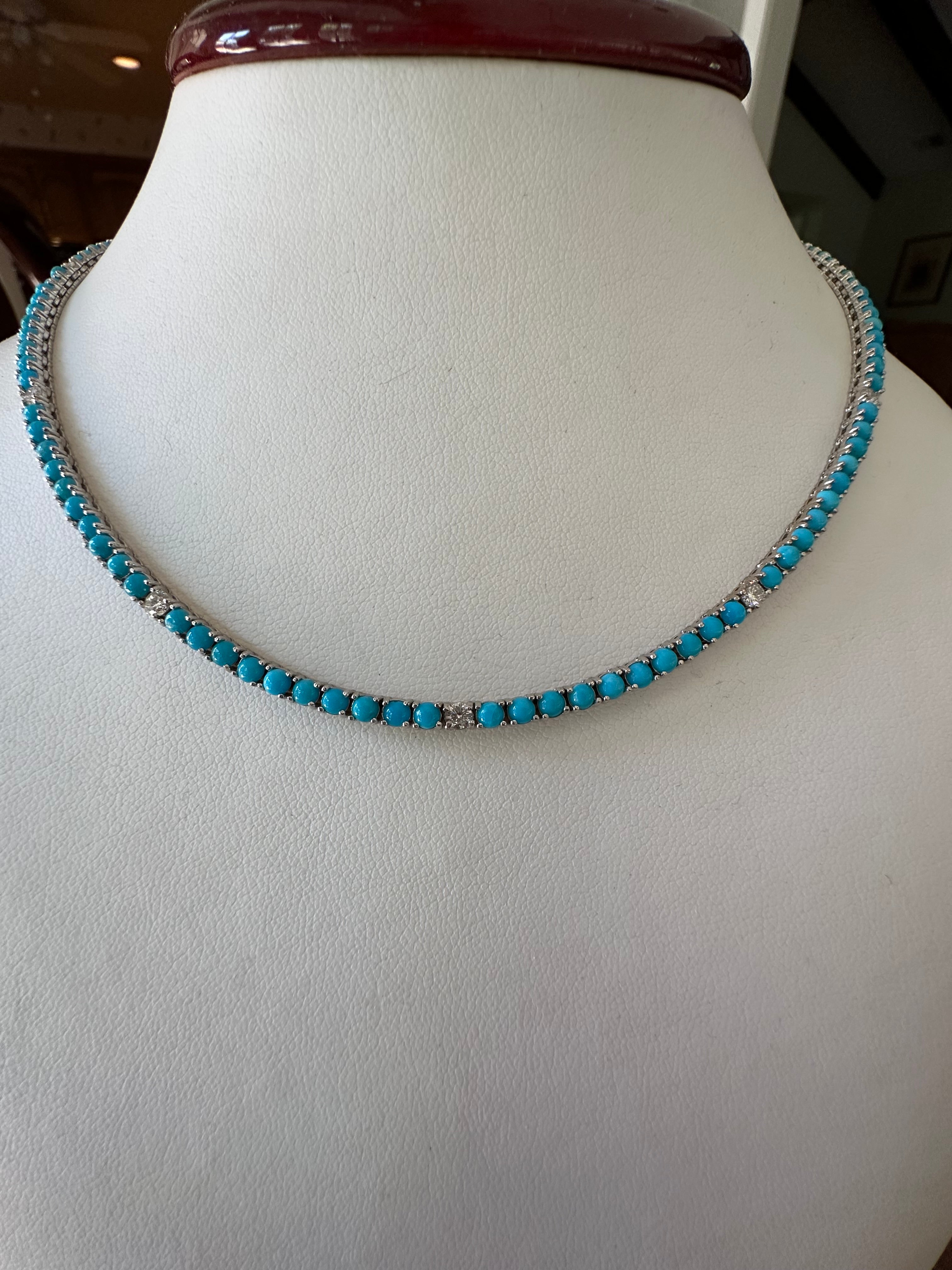 This exquisite tennis necklace set in 14K white gold features one hundred twenty-two natural fine turquoise round-shaped cabochons-- all hand cut to match-- interspersed with nine natural white round brilliant-cut diamonds totaling 0.90 carats, F-G