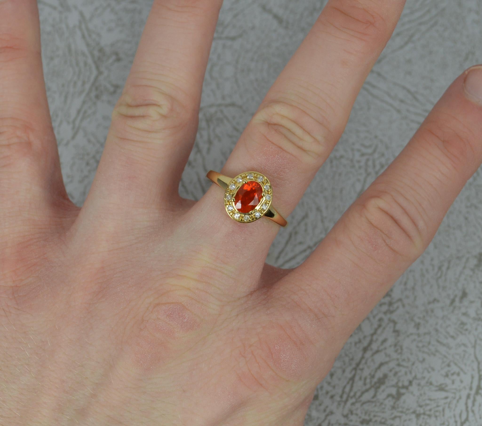 A superb Fire Opal and Diamond ring.
18 carat yellow gold example.
5.1mm x 7.1mm oval fire opal to centre in four claw setting surrounded by 12 natural diamonds.
9.8mm x 11.3mm cluster head.

Condition ; Excellent. Well set stones. Strong and solid