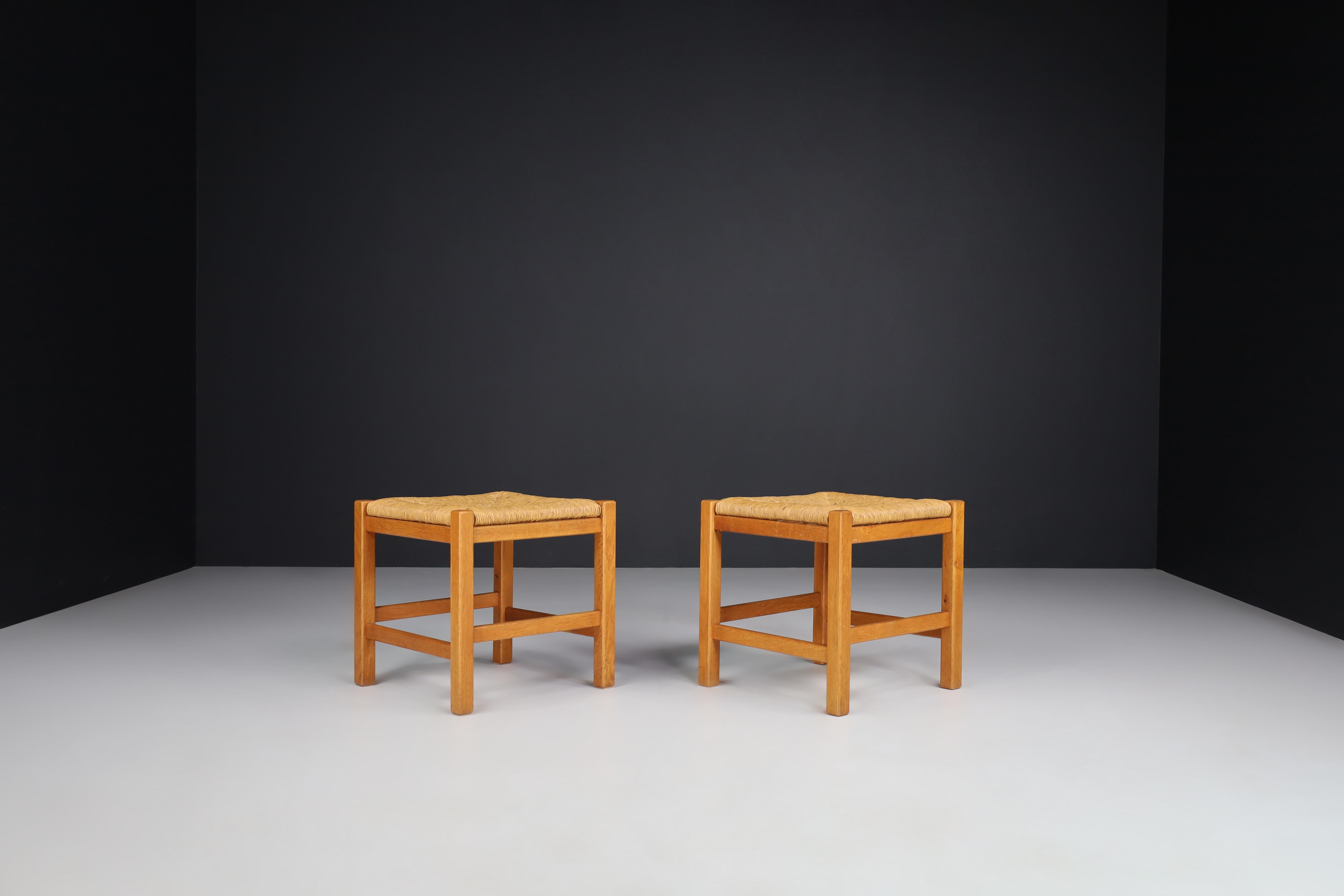 Pair of two French stools in the style of Charlotte Perriand, France, 1950s. 

These solid oak stools show a lovely natural patina, are in excellent original condition and have a great patina and natural wear to the wood and rush. These stools would