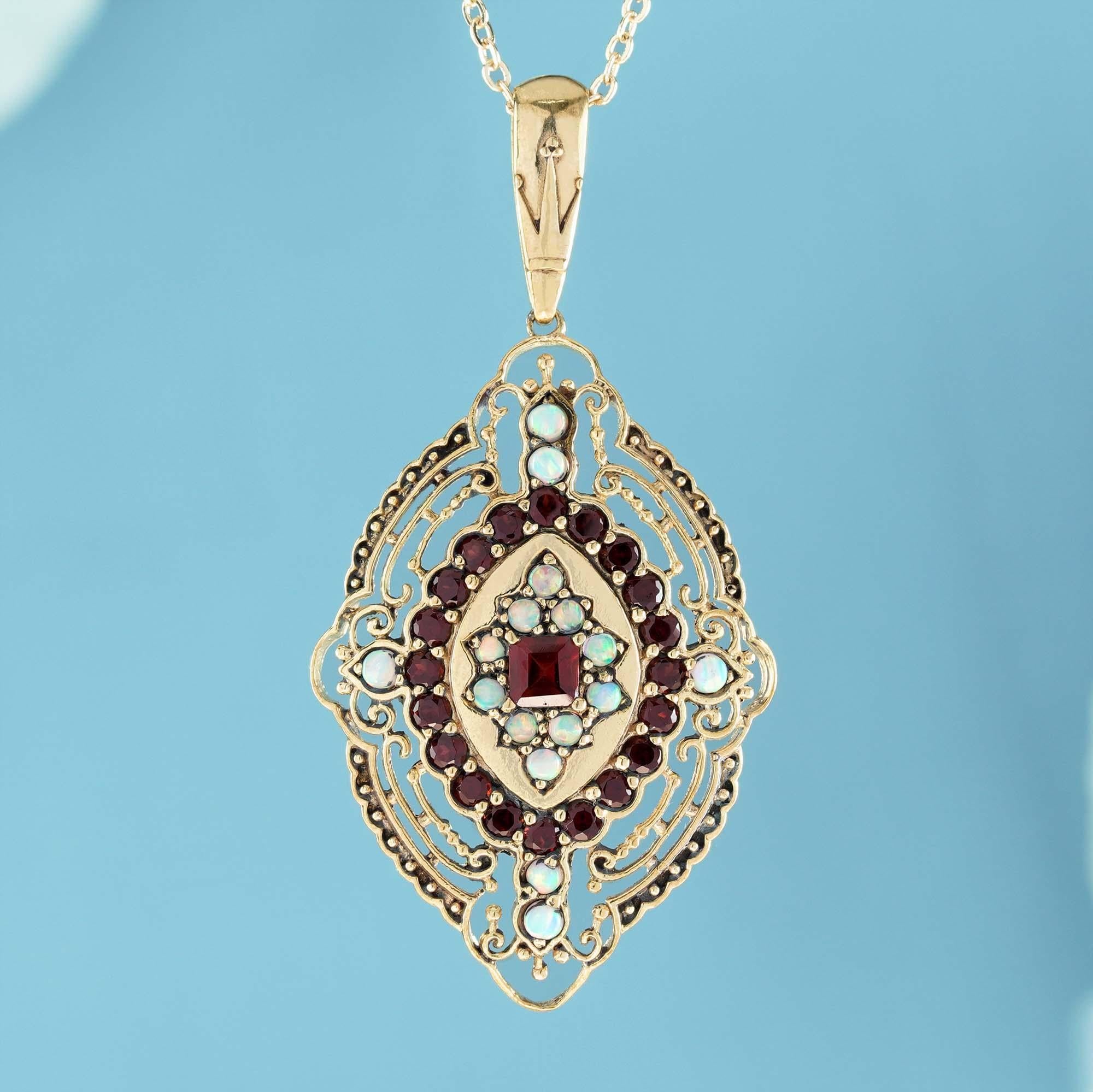 Honoring the memoir of timeless, antique jewelry. The pendant is set delicately and ornately in a yellow gold, with scrolls and flourishes of the filigree that echo the square shape of the red garnet gemstone in the center. surrounded by opal and
