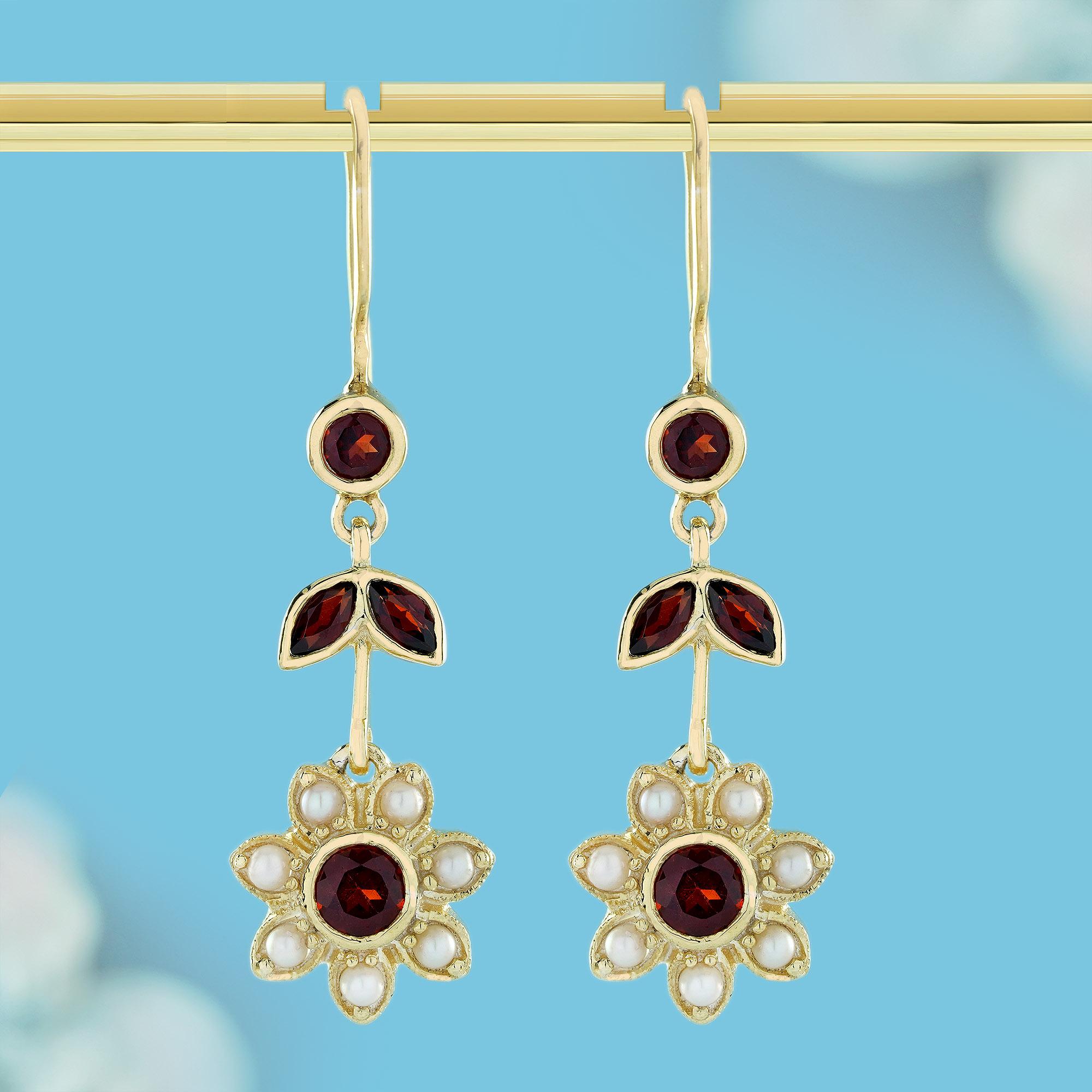 These vintage-style floral dangle earrings feature multiple sections connected to evoke a sense of movement and grace. At the top, a small round red garnet set in gold is followed by two leaf-shaped gold pieces, each adorned with marquise garnets.