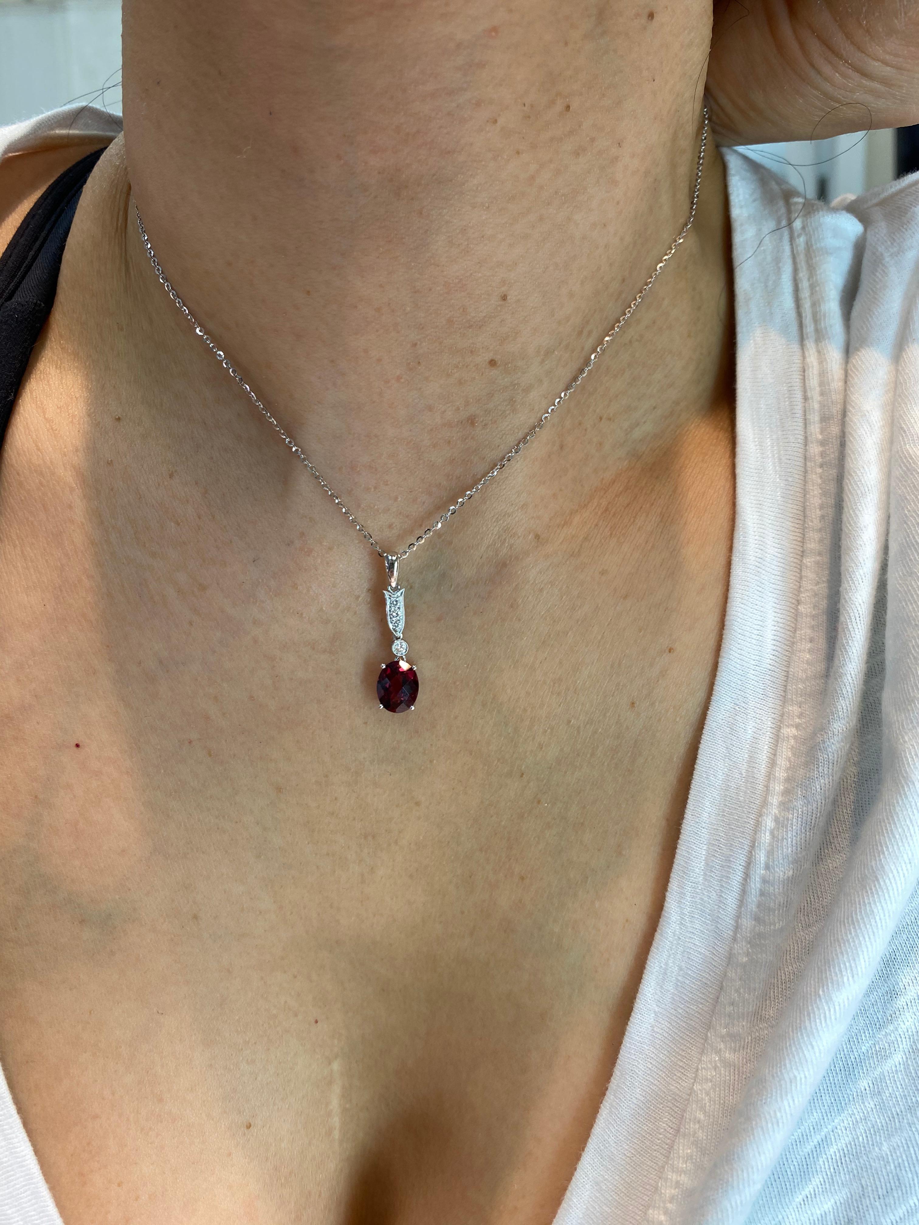 Here is a natural garnet and diamond pendant. The pendant is set in 18k white gold and diamonds. There are estimated 0.08 cts of diamonds set on top of the faceted oval-shaped garnet. The natural garnet is full of life. It sparkles with fire. This