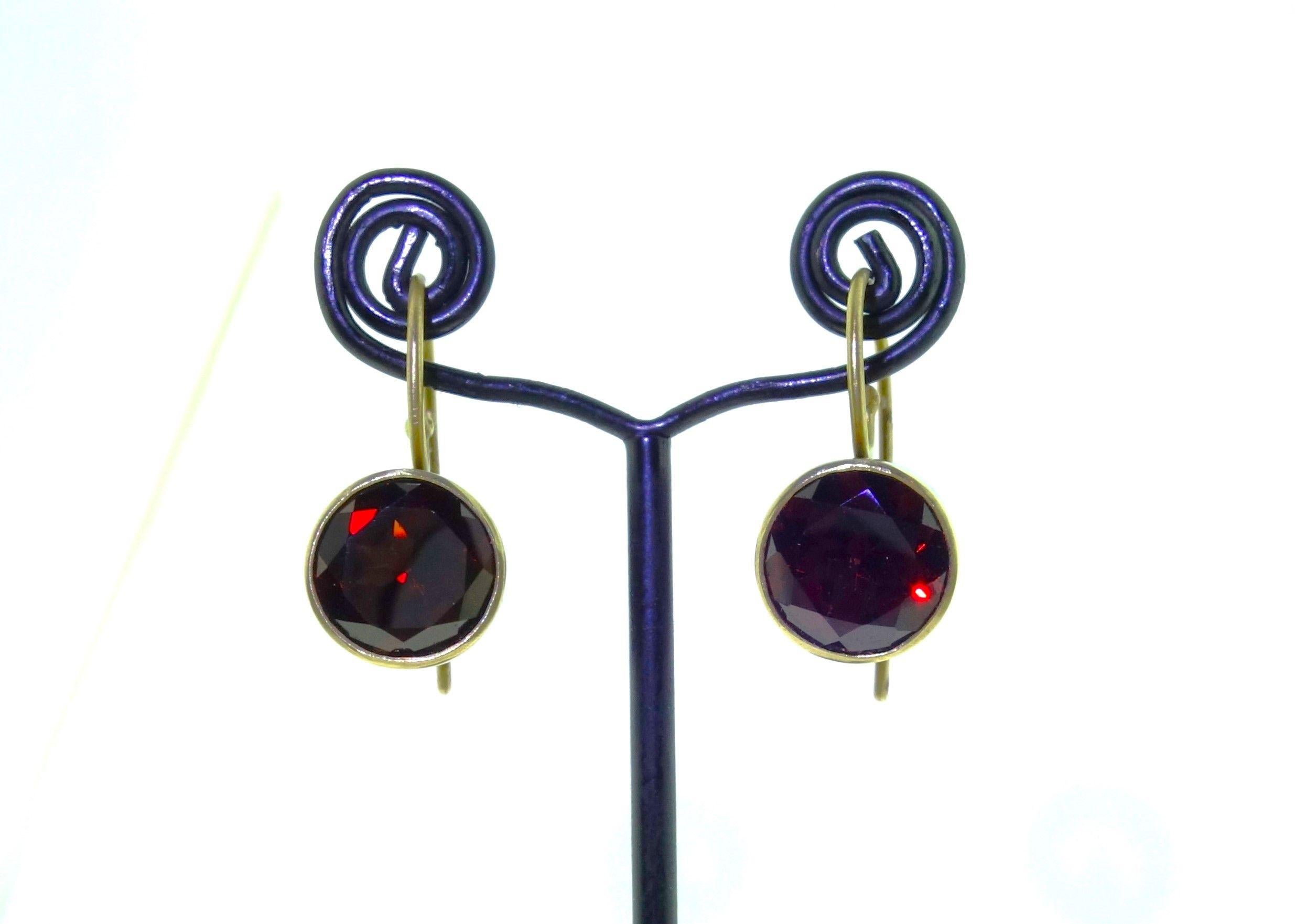 Simply Beautiful! Natural Garnet Gold and Sterling Silver Drop Earrings. Each Earring centering a 10mm Round Natural Garnet. Earring Size: 23mm long x 16mm x 10mm. Natural Swiss Blue Topaz weighing approx. 8.03tcw. Hand crafted Bi-metal Design 18K