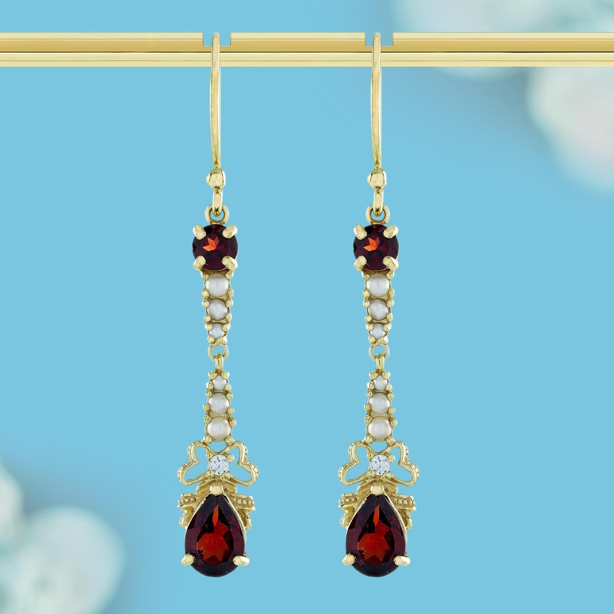 Indulge in timeless elegance with these captivating vintage-inspired earrings. The yellow gold setting features a drop design adorned with natural garnet, pearl, and diamond accents, they exude a classic and elegant allure. A smaller round garnet