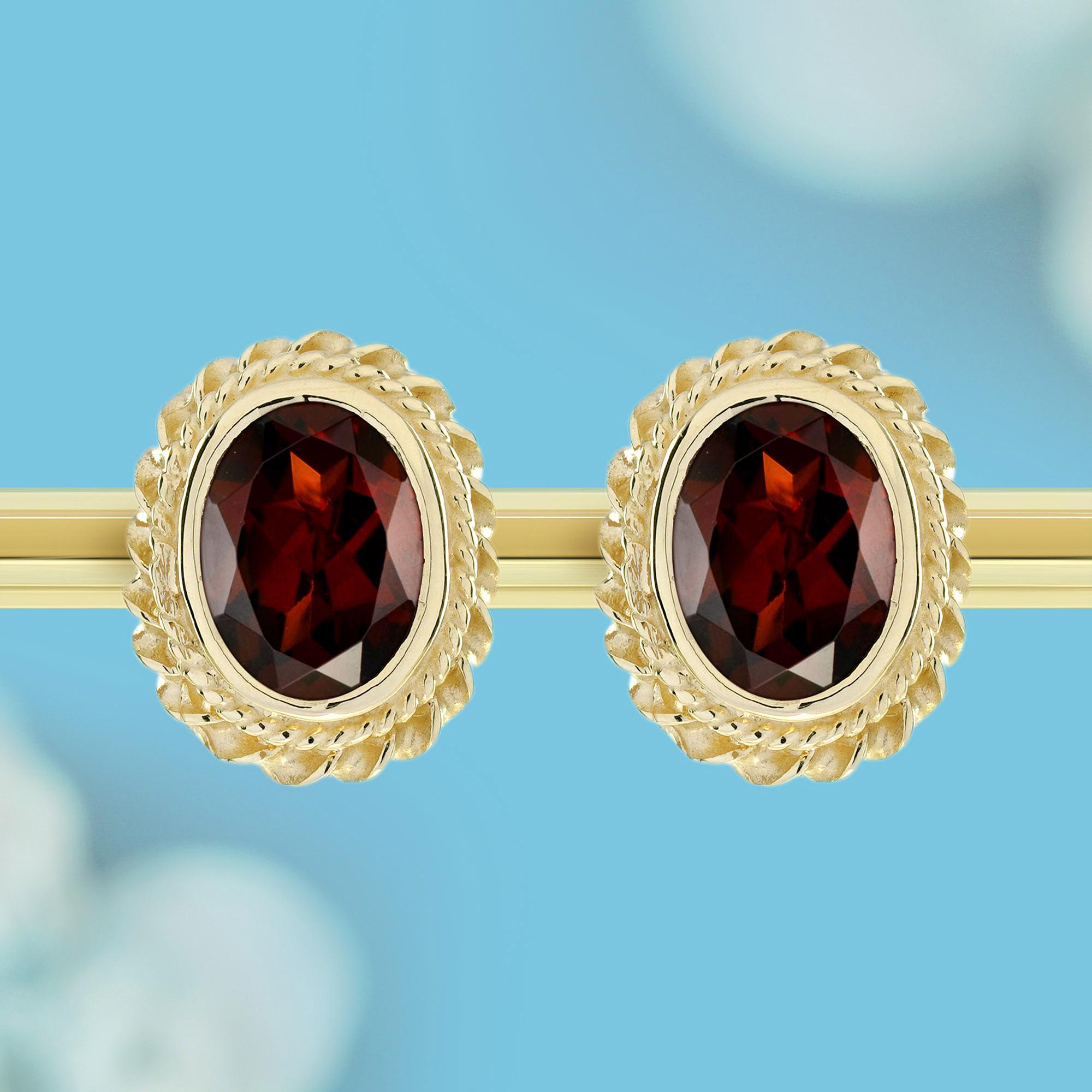 These classic elegance meets fiery brilliance in these captivating stud earrings. Crafted from warm yellow gold, the earrings boast a vintage-inspired rope motif that adds a touch of timeless charm. At the heart of each piece lies a stunning red