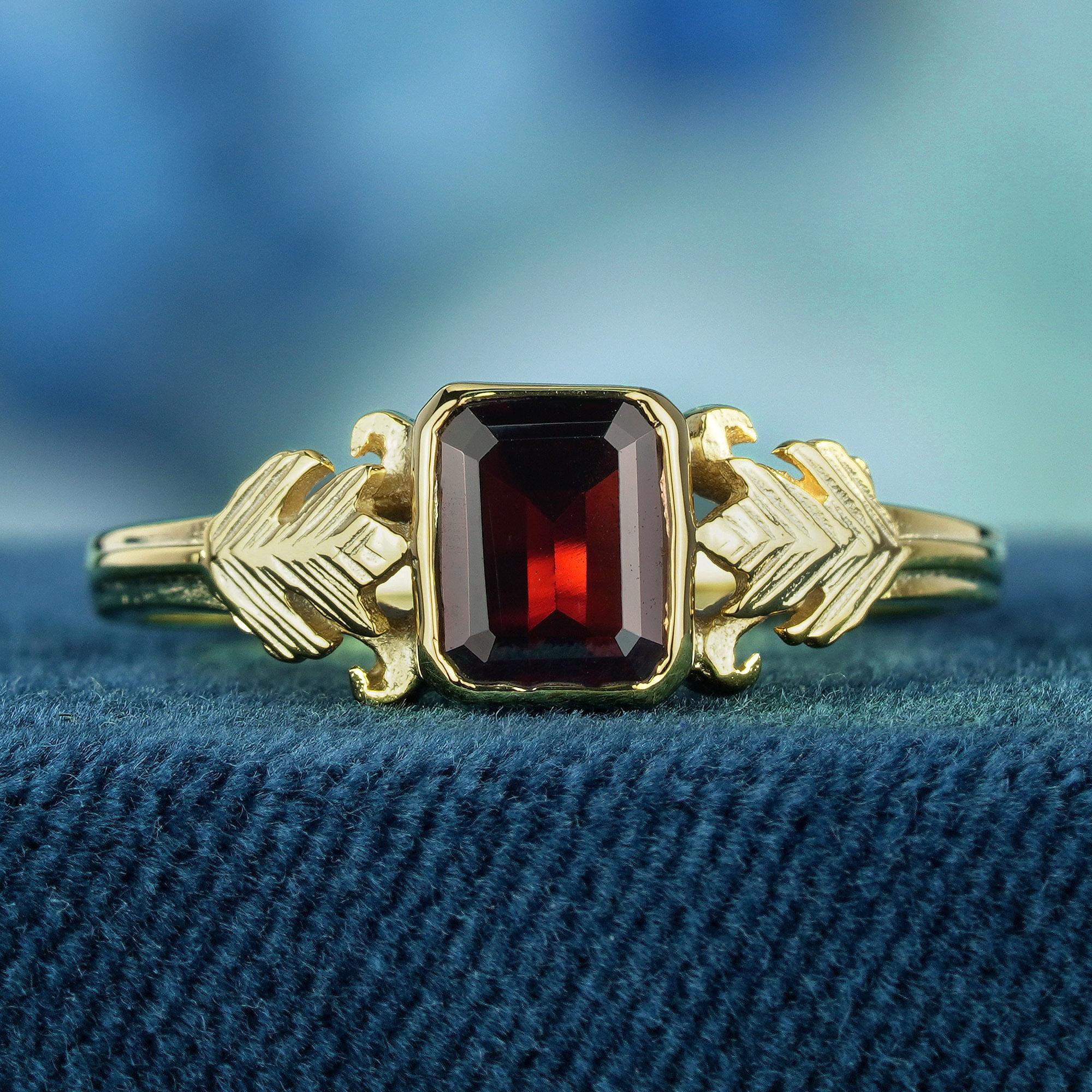 Indulge in the timeless allure of this vintage-inspired ring, a testament to refined elegance. Delicately crafted and embellished with a deep red, emerald-cut garnet stone, nestled within a radiant yellow gold band that gleams with luxurious allure.