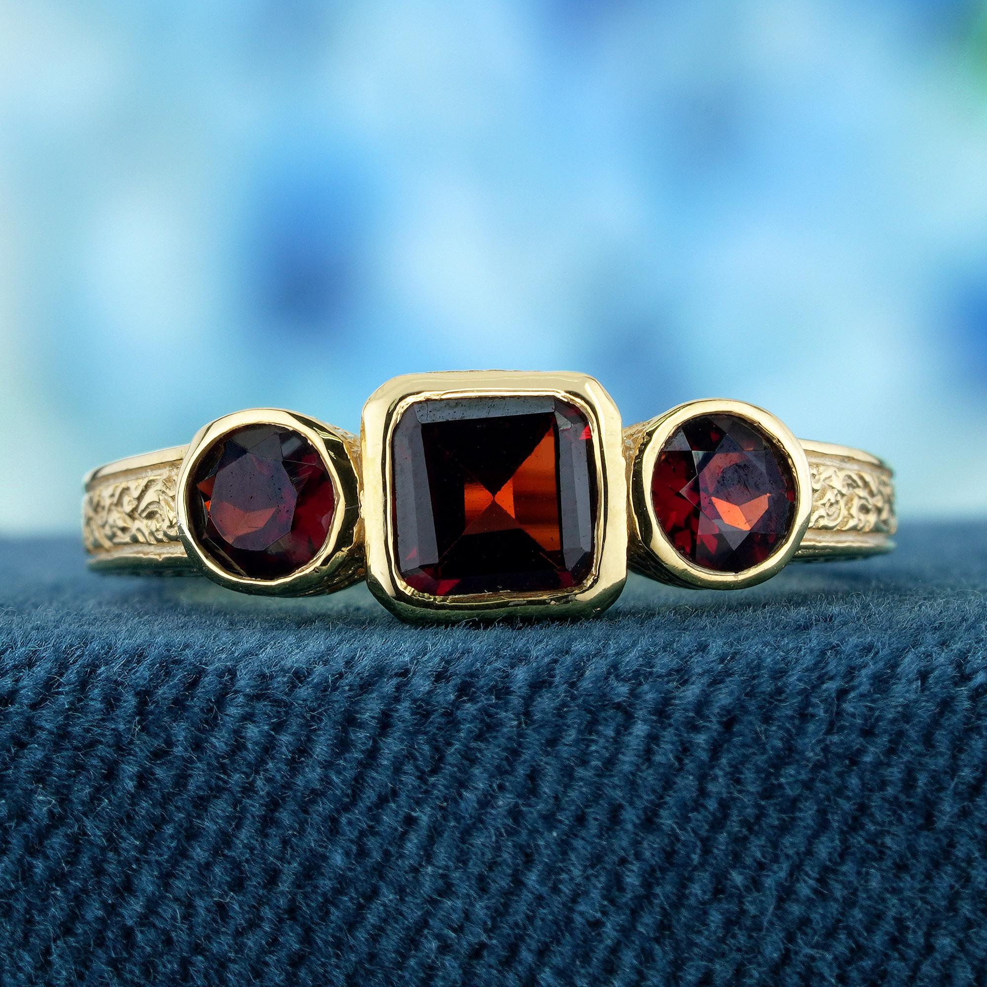 Der Ring ist im Vintage-Stil gehalten und zeichnet sich durch aufwändige Details und eine zeitlose Ästhetik aus. Die Fassung aus Gelbgold bietet eine warme und reiche Kulisse für die Edelsteine. Das Herzstück des Rings sind drei natürliche, ovale