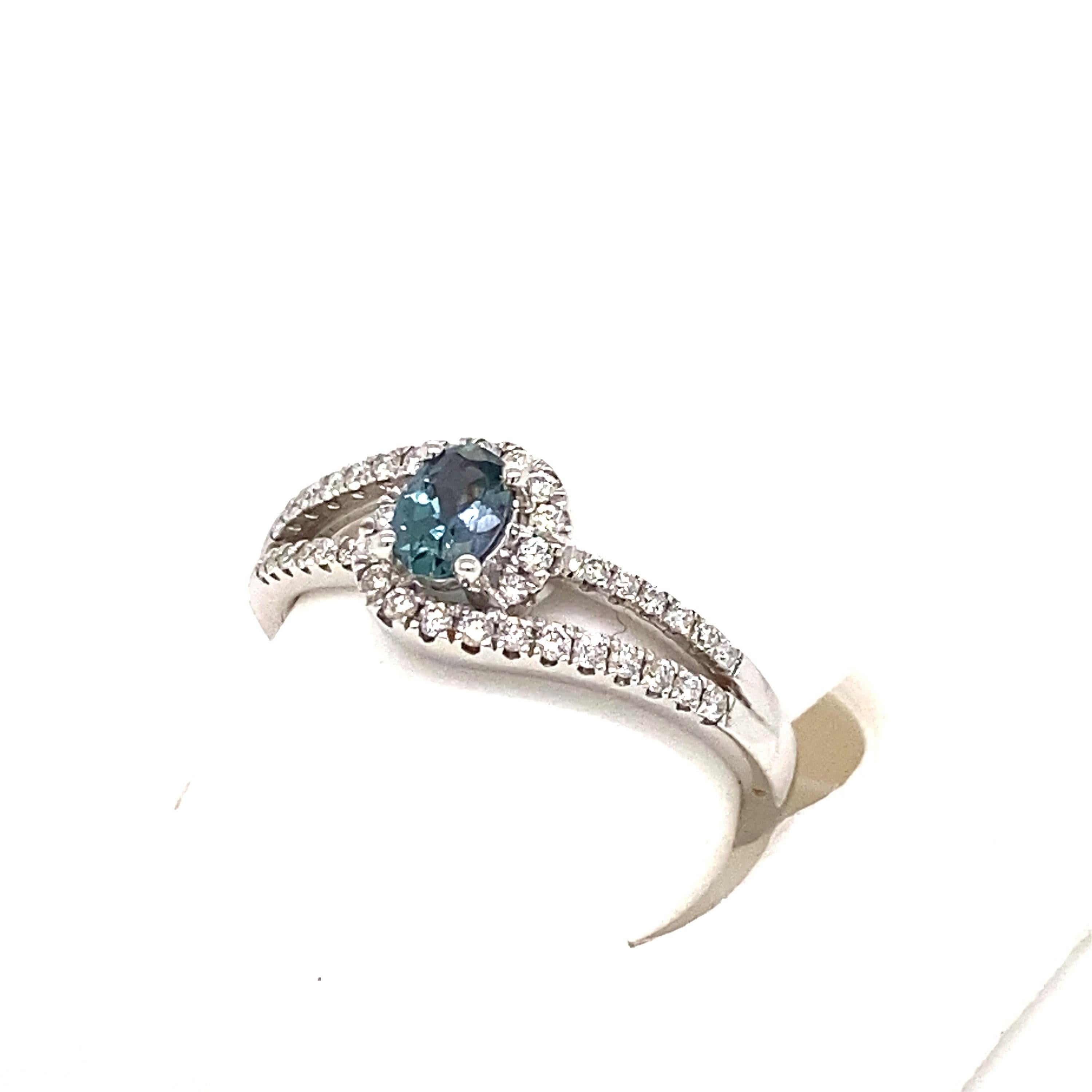 This is a gorgeous natural AAA quality oval Alexandrite surrounded by dainty diamonds that are set in a vintage white gold setting. This ring features a natural 0.40 carat oval alexandrite that is certified by the Gemological Institute of America