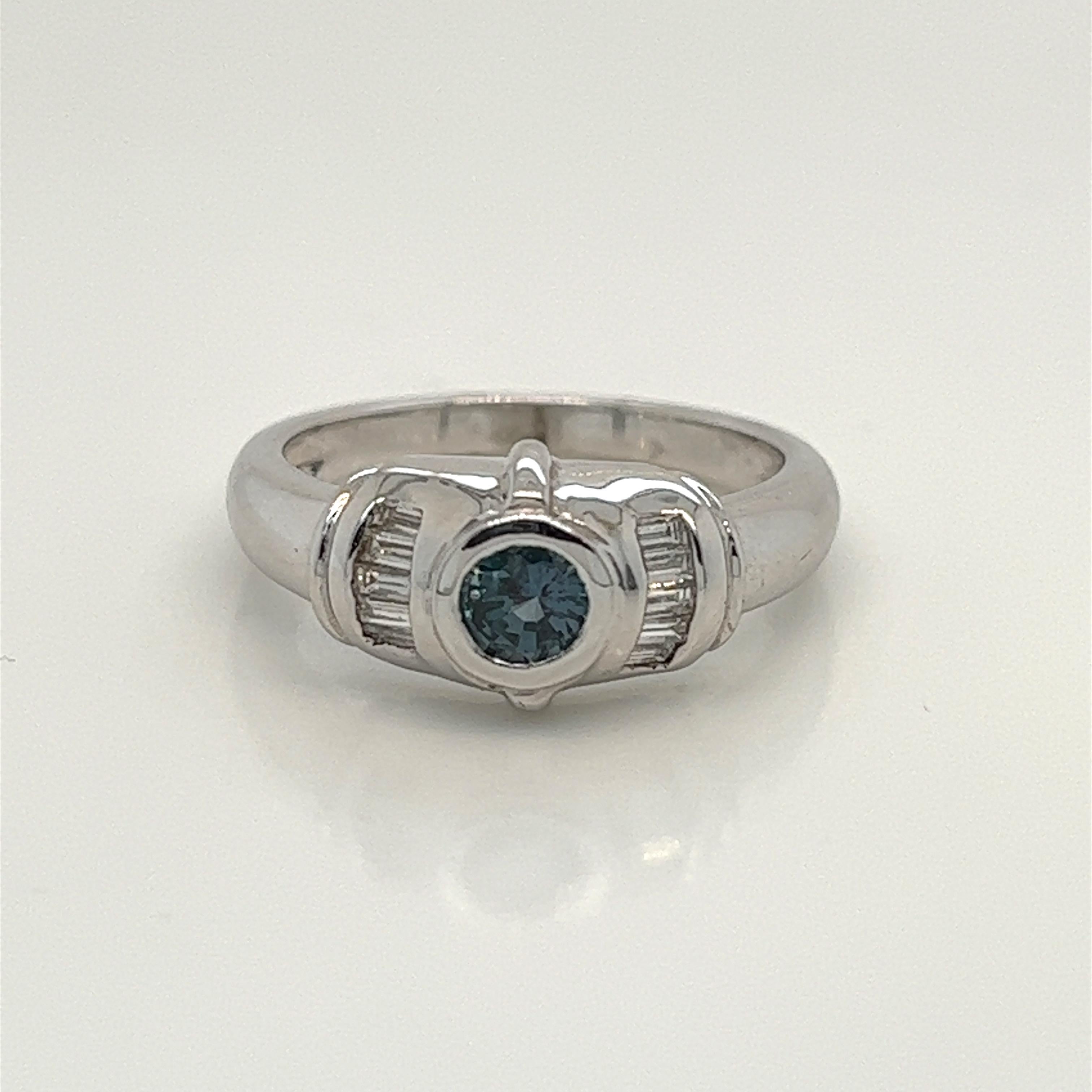 This is a gorgeous natural AAA quality Round Alexandrite with Baguette diamonds that is set in solid 18K white gold. This ring features a natural 0.53 carat round alexandrite that is certified by the Gemological Institute of America (GIA). The ring