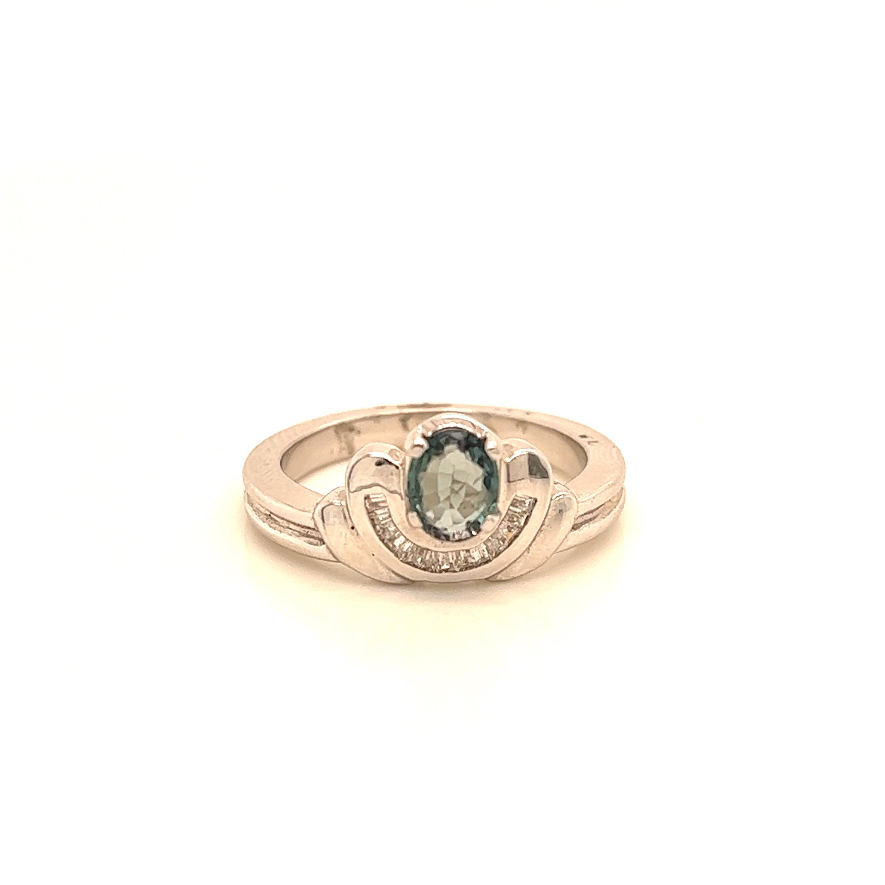 This is a gorgeous natural AAA quality Oval Alexandrite with Baguette diamonds that is set in solid 18K white gold. This ring features a natural 0.73 carat oval alexandrite that is certified by the Gemological Institute of America (GIA). The ring is