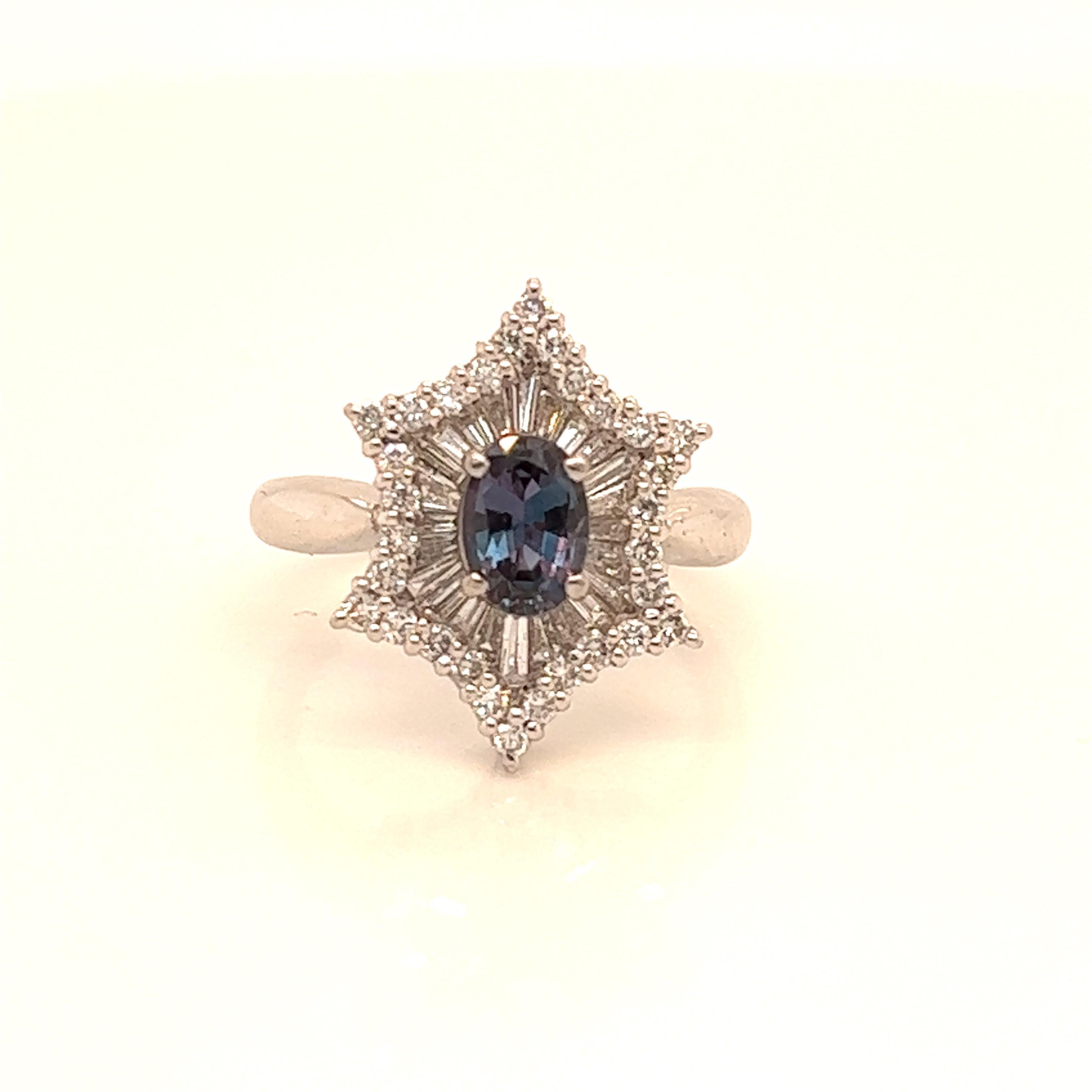 This is a gorgeous natural AAA quality Oval Alexandrite surrounded by dainty diamonds that is set in a vintage platinum setting. This ring features a natural 0.76 carat oval alexandrite that is certified by the Gemological Institute of America (GIA)