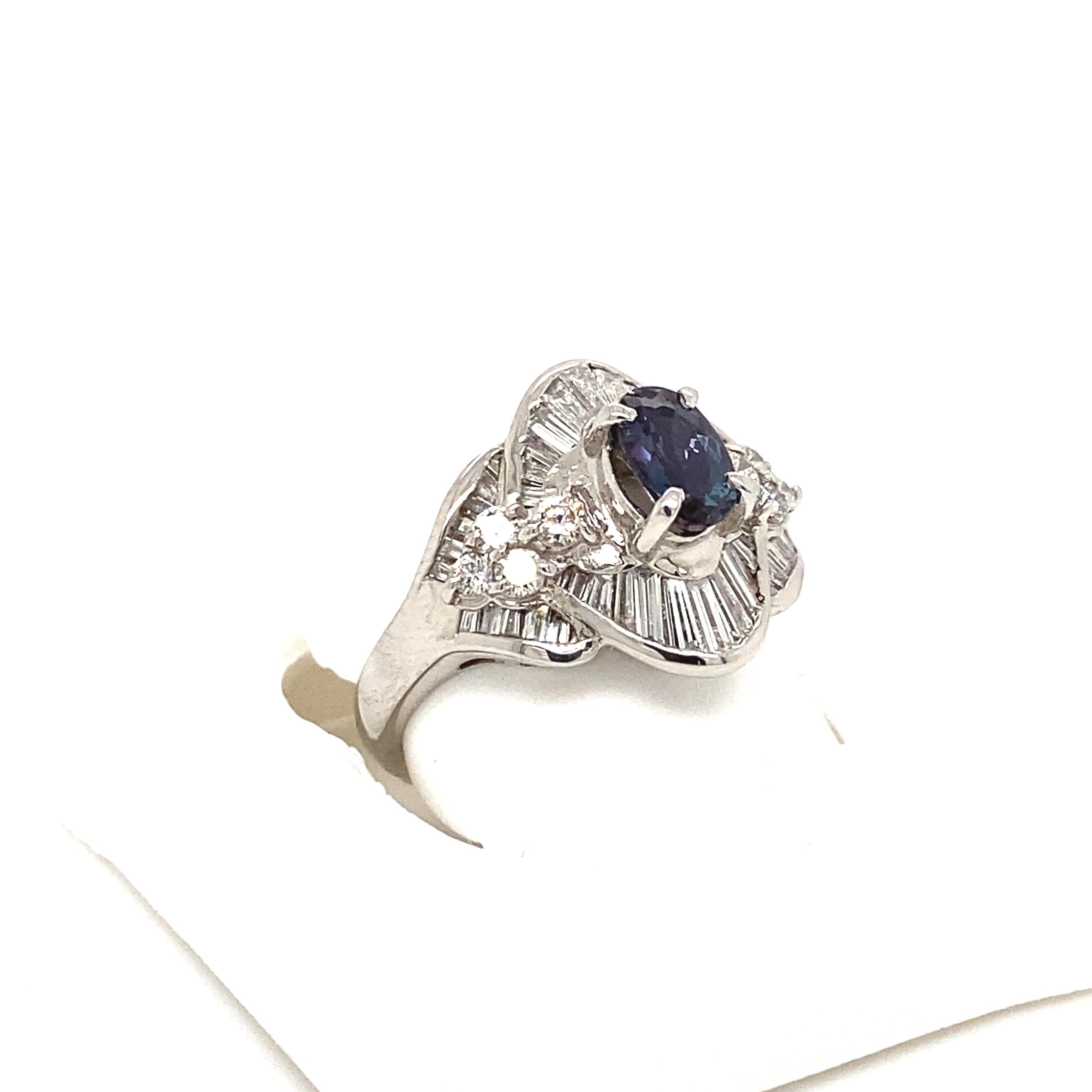 This is a gorgeous natural AAA quality oval Alexandrite surrounded by dainty diamonds that is set in a vintage platinum setting. This ring features a natural 0.85 carat brazillian oval alexandrite that is certified by the Gemological Institute of