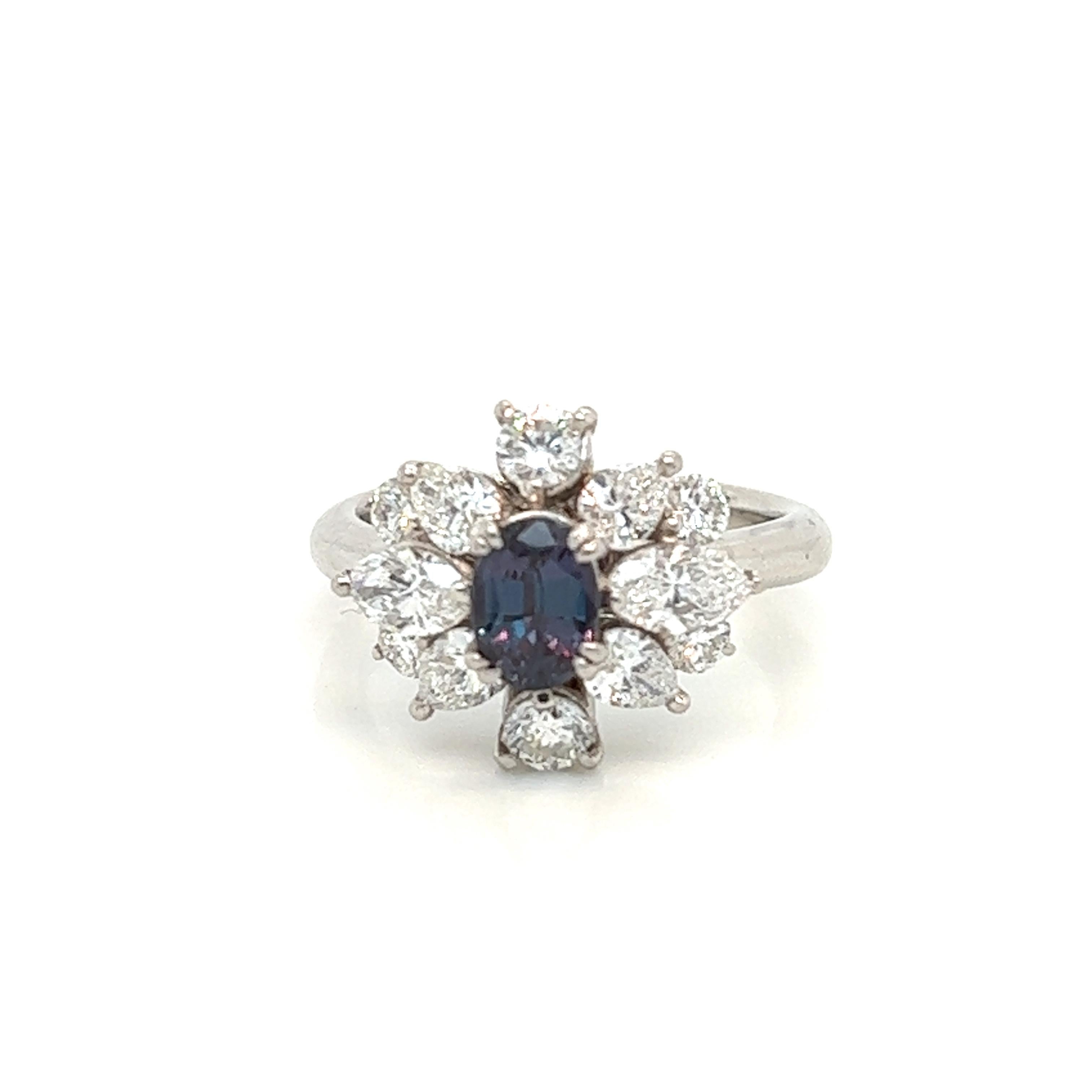 This is a gorgeous natural AAA quality oval Alexandrite surrounded by dainty diamonds that is set in a vintage platinum setting. This ring features a natural 0.85 carat oval alexandrite that is certified by the Gemological Institute of America (GIA)