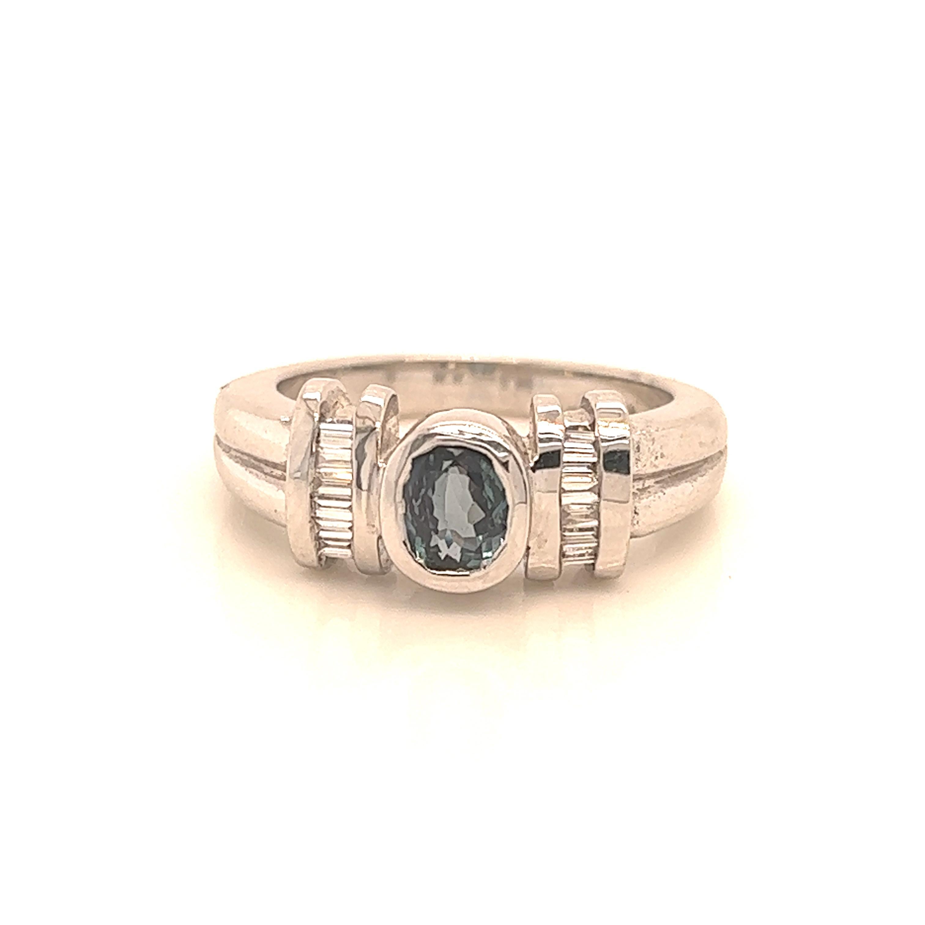 This is a gorgeous natural AAA quality oval Alexandrite surrounded by dainty diamonds that is set in a vintage White Gold setting. This ring features a natural 0.87 carat oval alexandrite that is certified by the Gemological Institute of America
