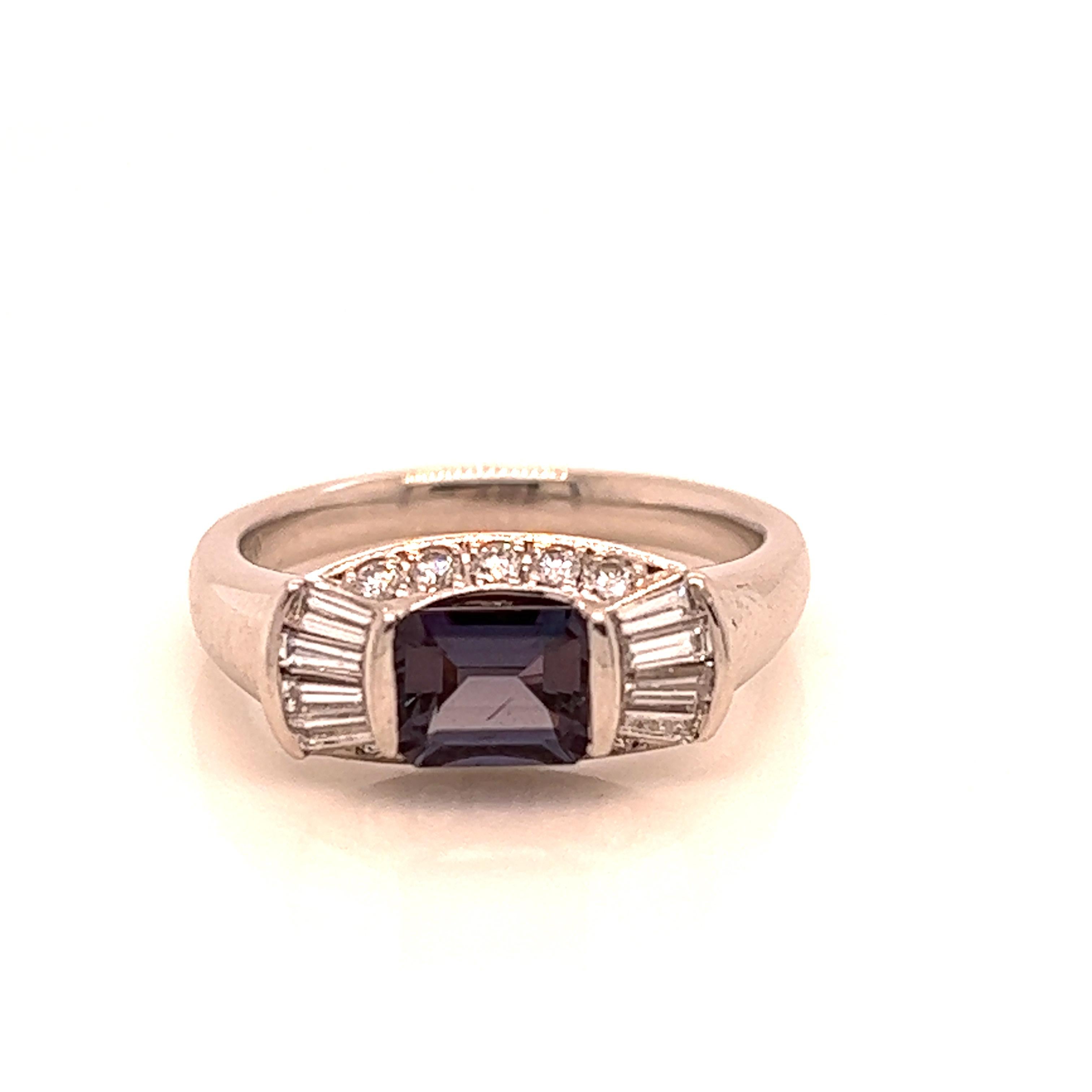 This is a gorgeous natural AAA quality emerald Alexandrite surrounded by dainty diamonds that is set in a vintage platinum setting. This ring features a natural 0.97 carat emerald alexandrite that is certified by the Gemological Institute of America