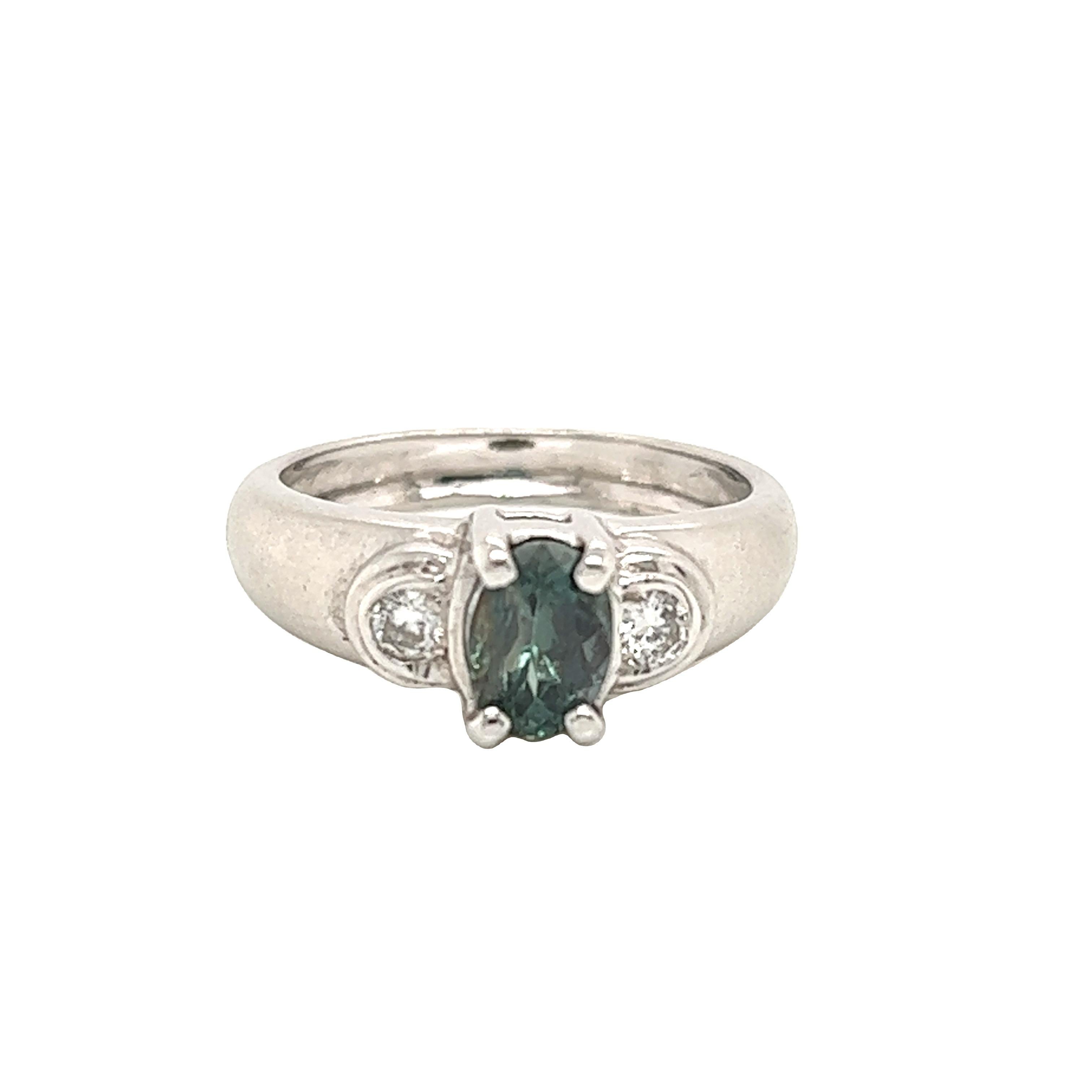 This is a gorgeous natural AAA quality oval Alexandrite surrounded by dainty diamonds that is set in a vintage White Gold setting. This ring features a natural 1.00 carat oval alexandrite that is certified by the Gemological Institute of America