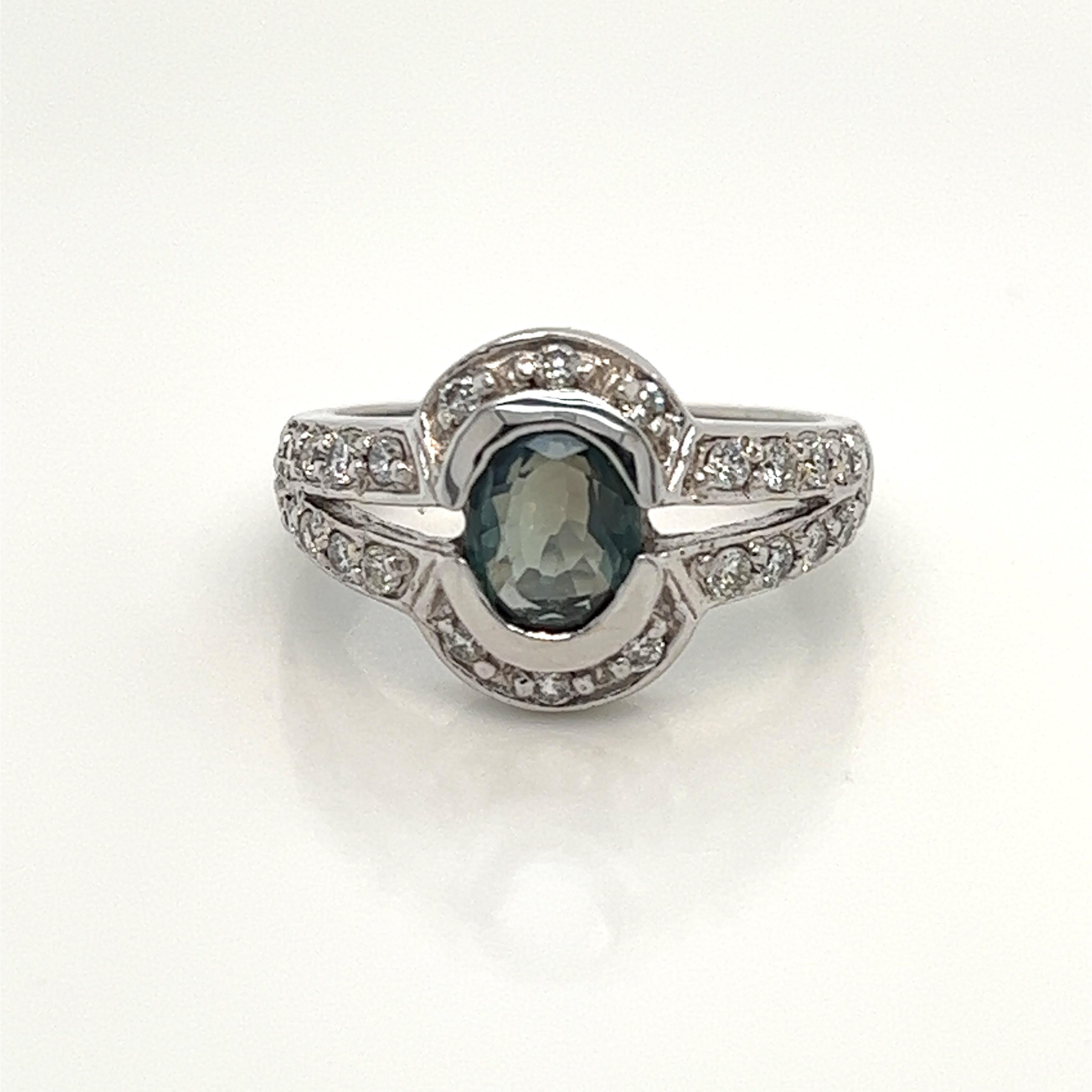 This is a gorgeous natural AAA quality Oval Alexandrite surrounded by dainty diamonds that is set in solid 18K white gold. This ring features a natural 1.23 carat Oval alexandrite that is certified by the Gemological Institute of America (GIA). The