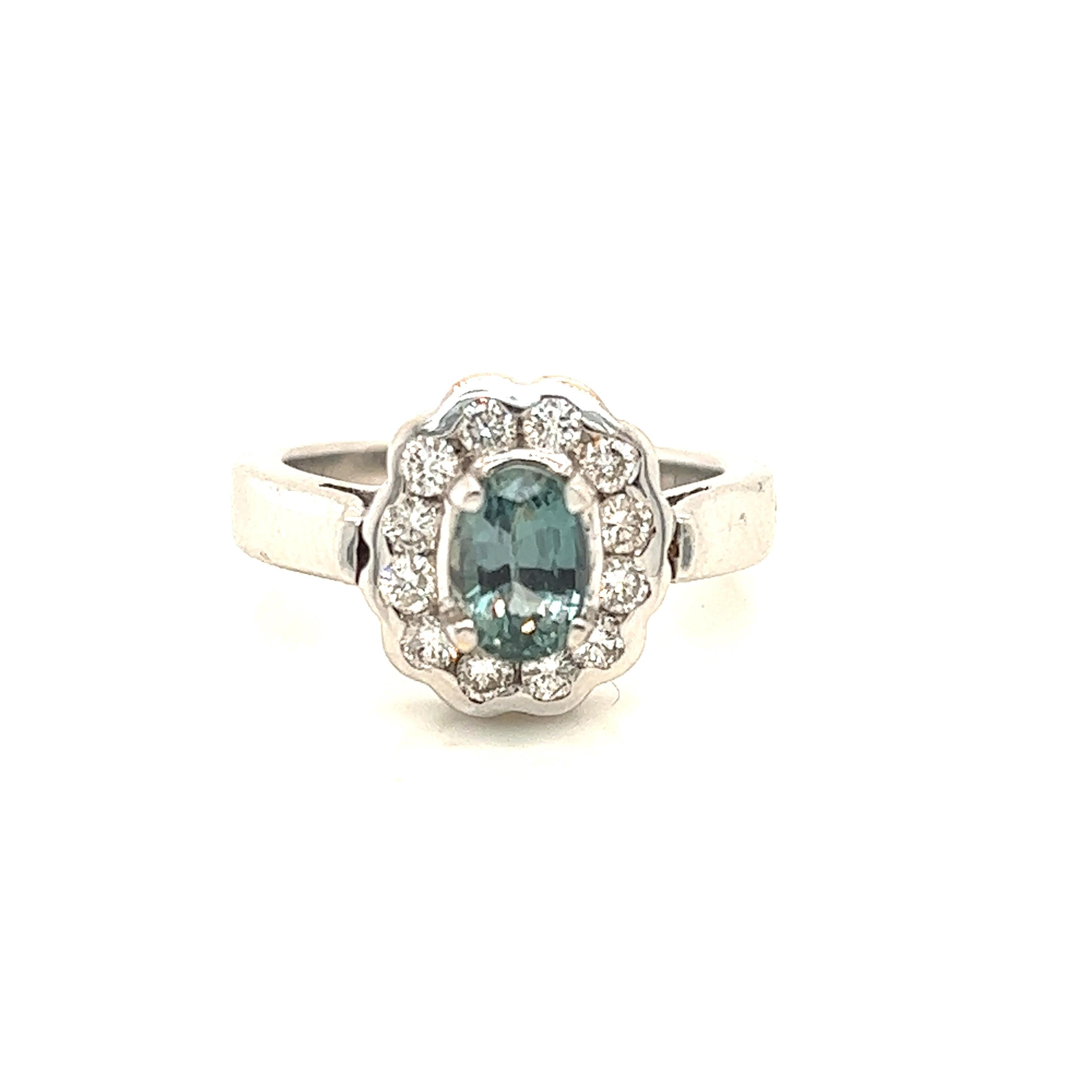This is a gorgeous natural AAA quality oval Alexandrite surrounded by dainty diamonds that is set in a vintage white gold setting. This ring features a natural 1.27 carat oval alexandrite that is certified by the Gemological Institute of America