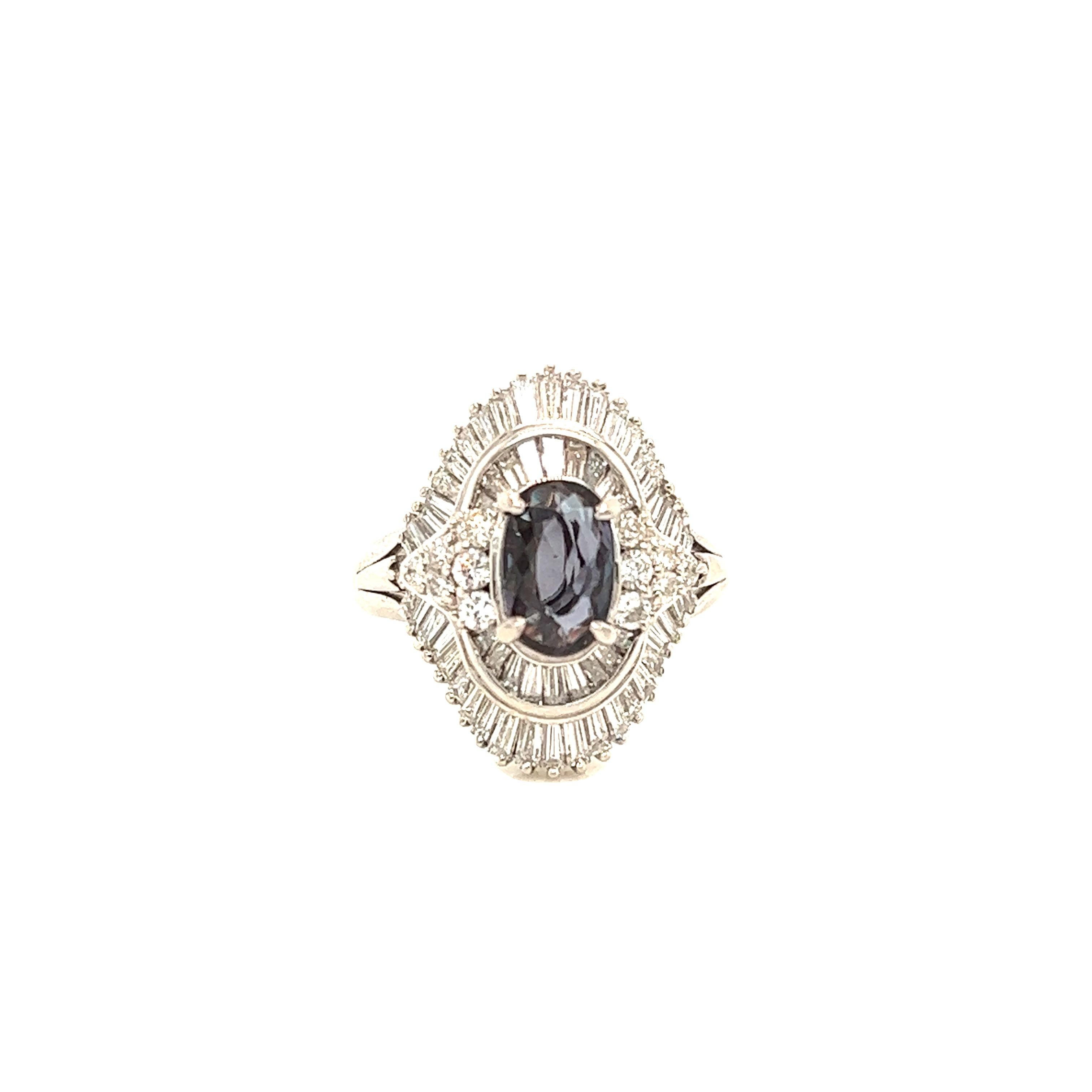 This is a gorgeous natural AAA quality oval Alexandrite surrounded by dainty diamonds that is set in a vintage white gold setting. This ring features a natural 1.40 carat oval alexandrite that is certified by the Gemological Institute of America