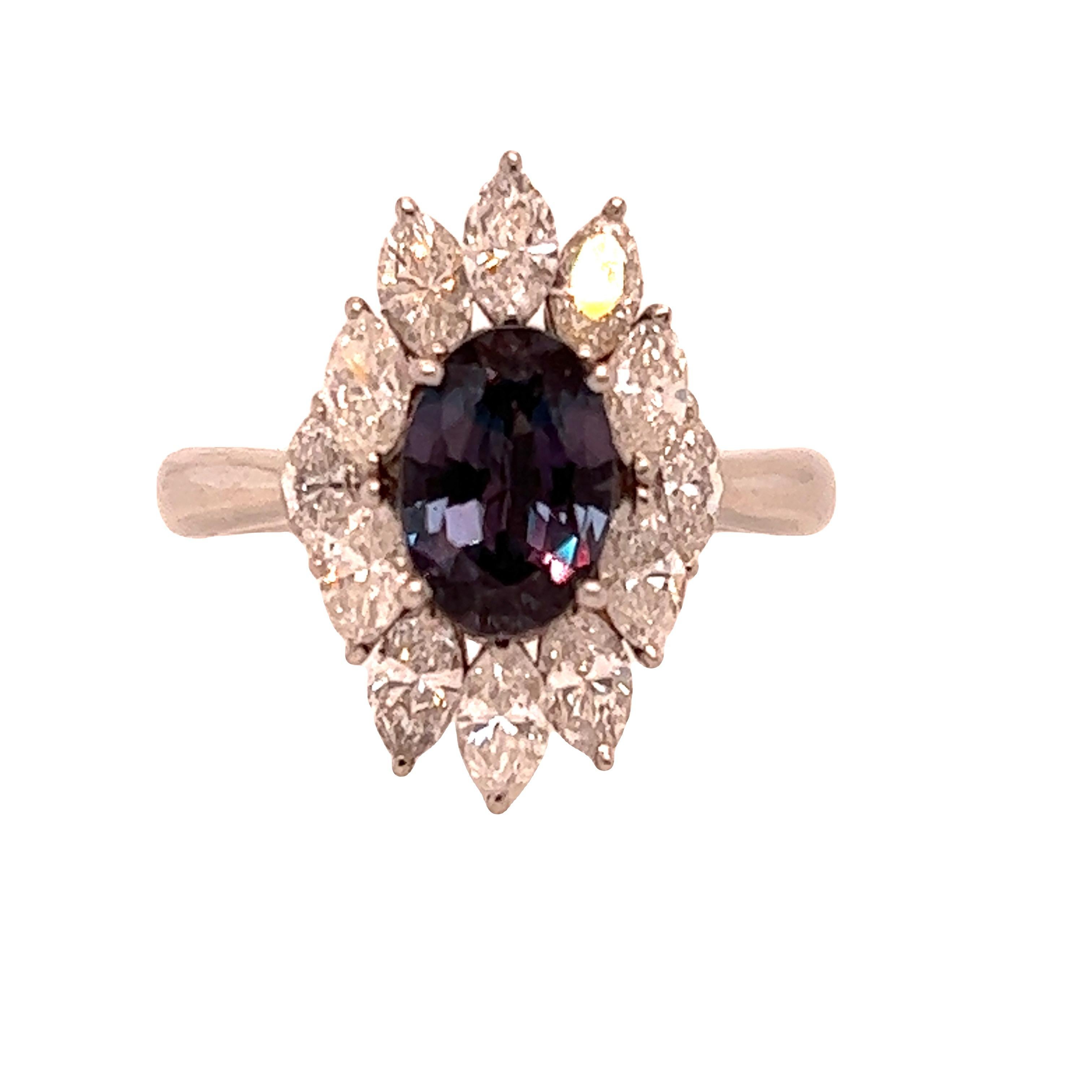 This is a gorgeous natural AAA quality oval Alexandrite surrounded by dainty diamonds that is set in a vintage platinum setting. This ring features a natural 1.41 carat oval alexandrite and is surrounded by brilliant white diamonds. The ring is a