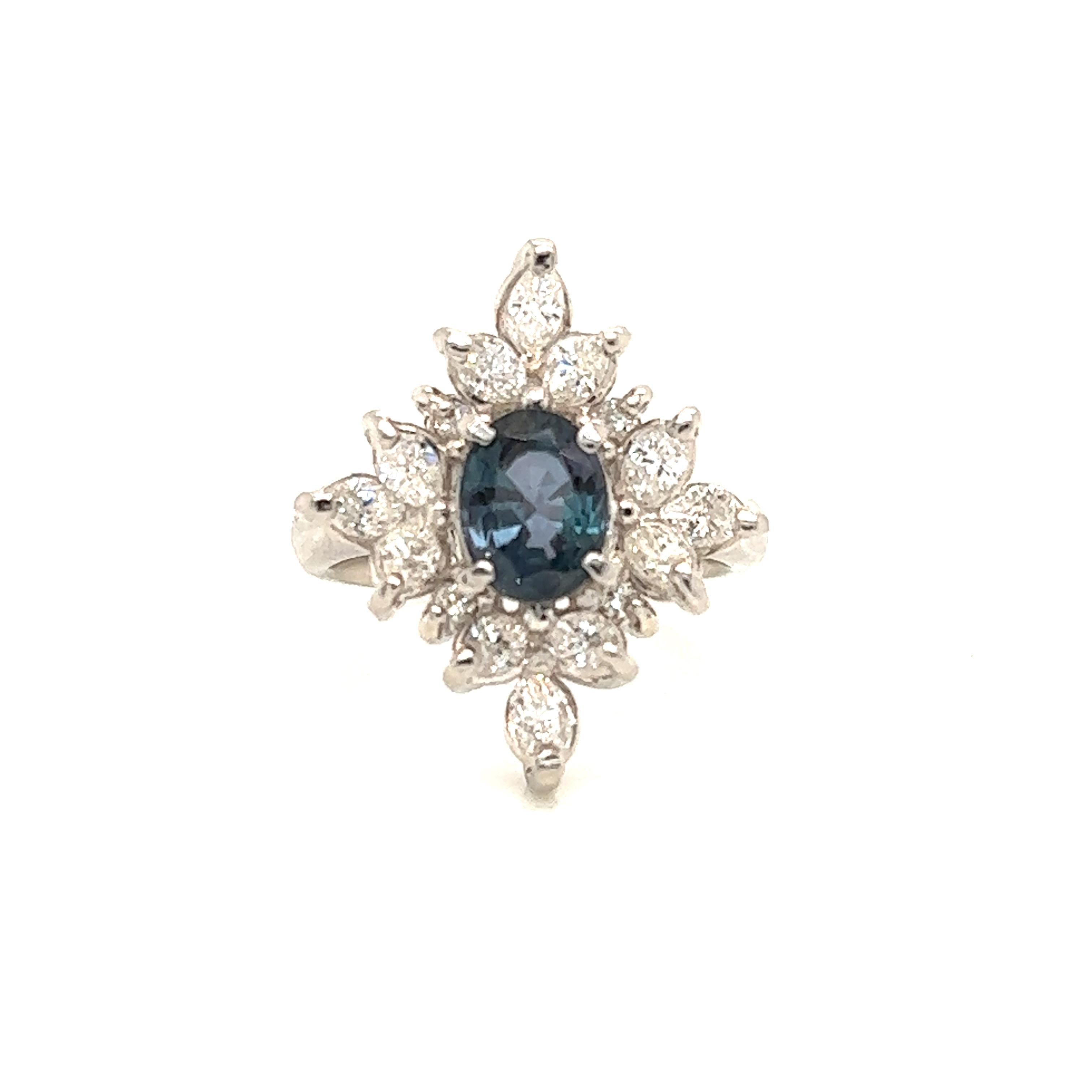 This is a gorgeous natural AAA quality Oval Alexandrite surrounded by dainty diamonds that is set in a vintage platinum setting. This ring features a natural 1.52 carat oval alexandrite that is certified by the Gemological Institute of America (GIA)