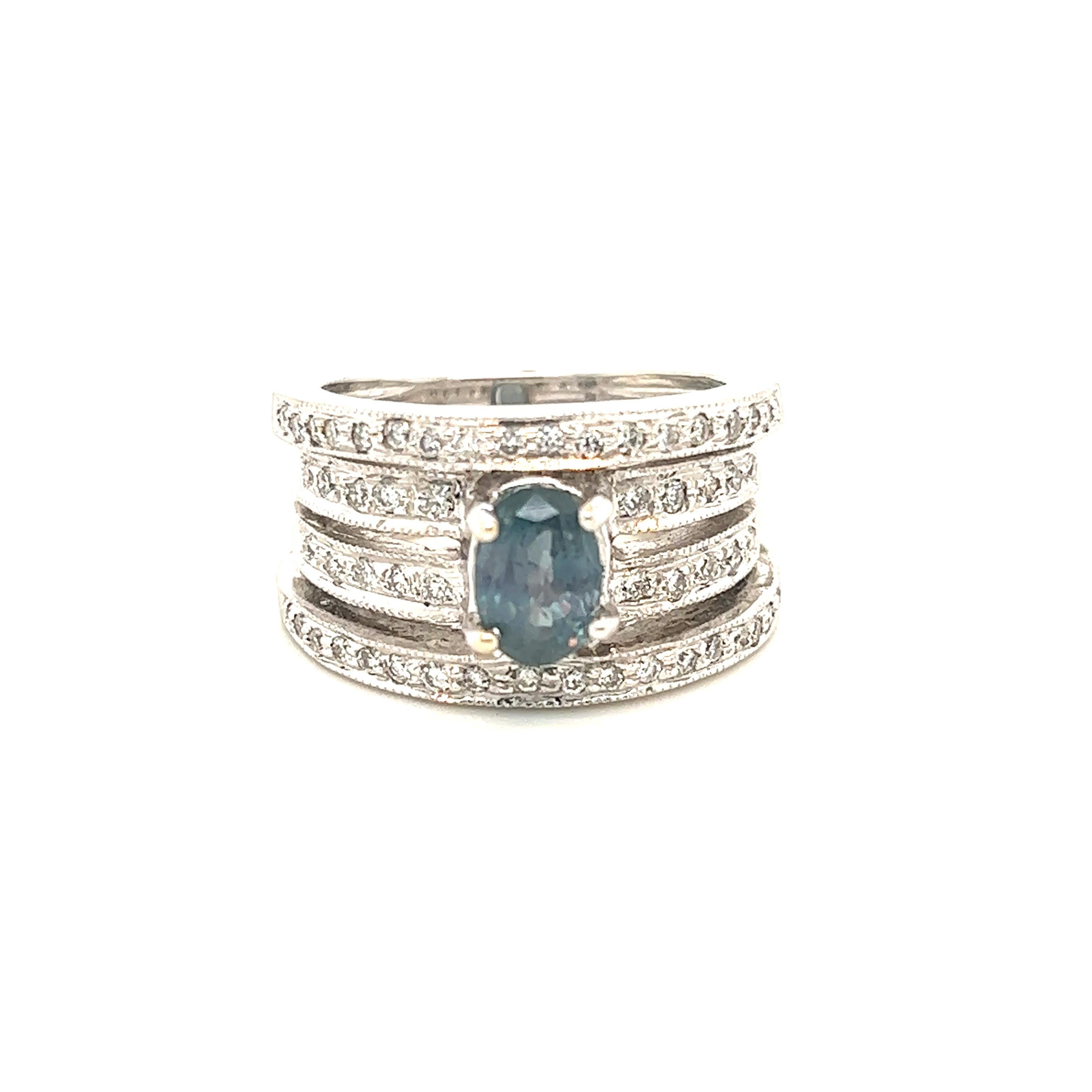 This is a gorgeous natural AAA quality oval Alexandrite surrounded by dainty diamonds that is set in a vintage white gold setting. This ring features a natural 1.71 carat oval alexandrite that is certified by the Gemological Institute of America
