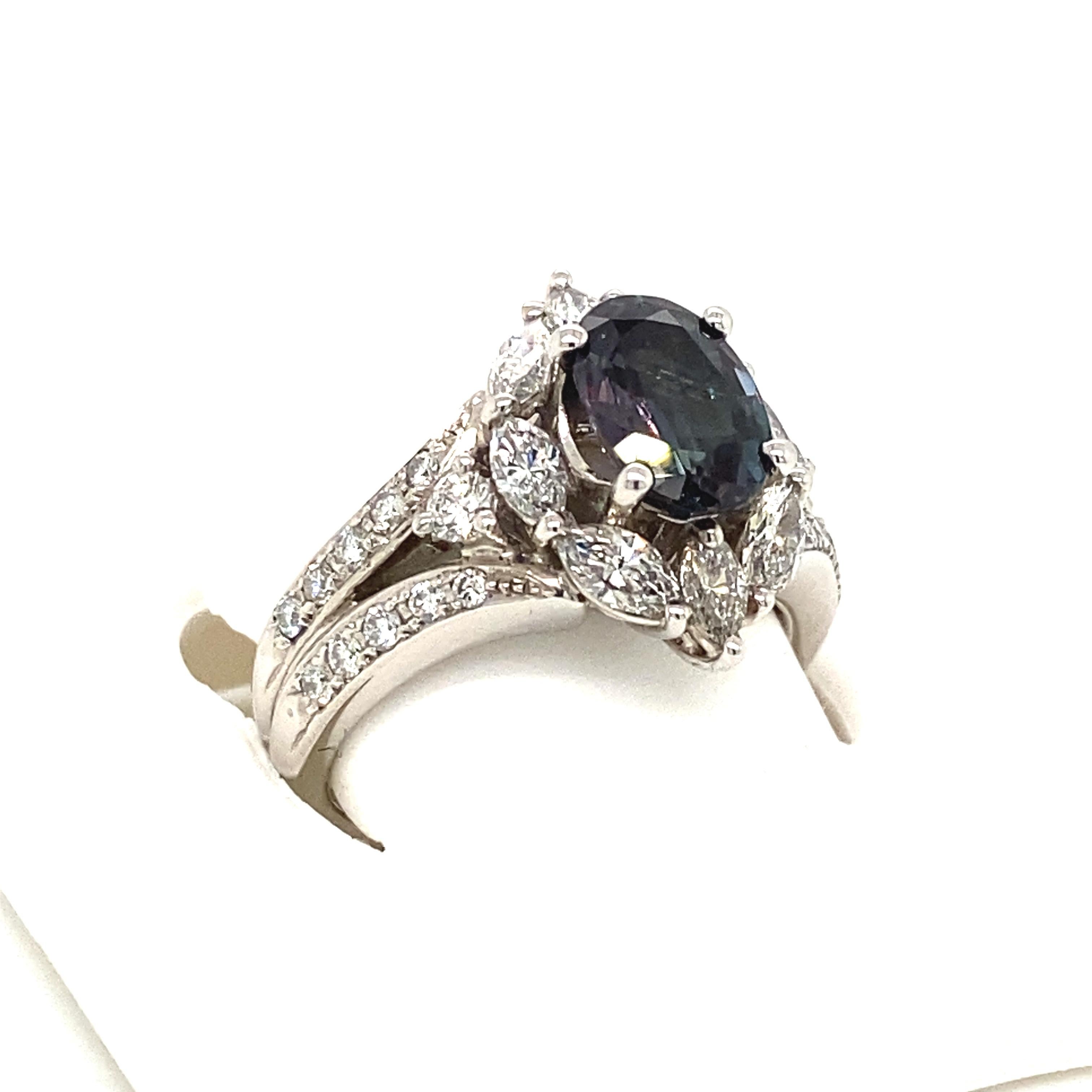 This is a gorgeous natural AAA quality oval Alexandrite surrounded by dainty diamonds that is set in a vintage platinum setting. This ring features a natural 1.74 carat brazillian oval alexandrite that is certified by the Gemological Institute of