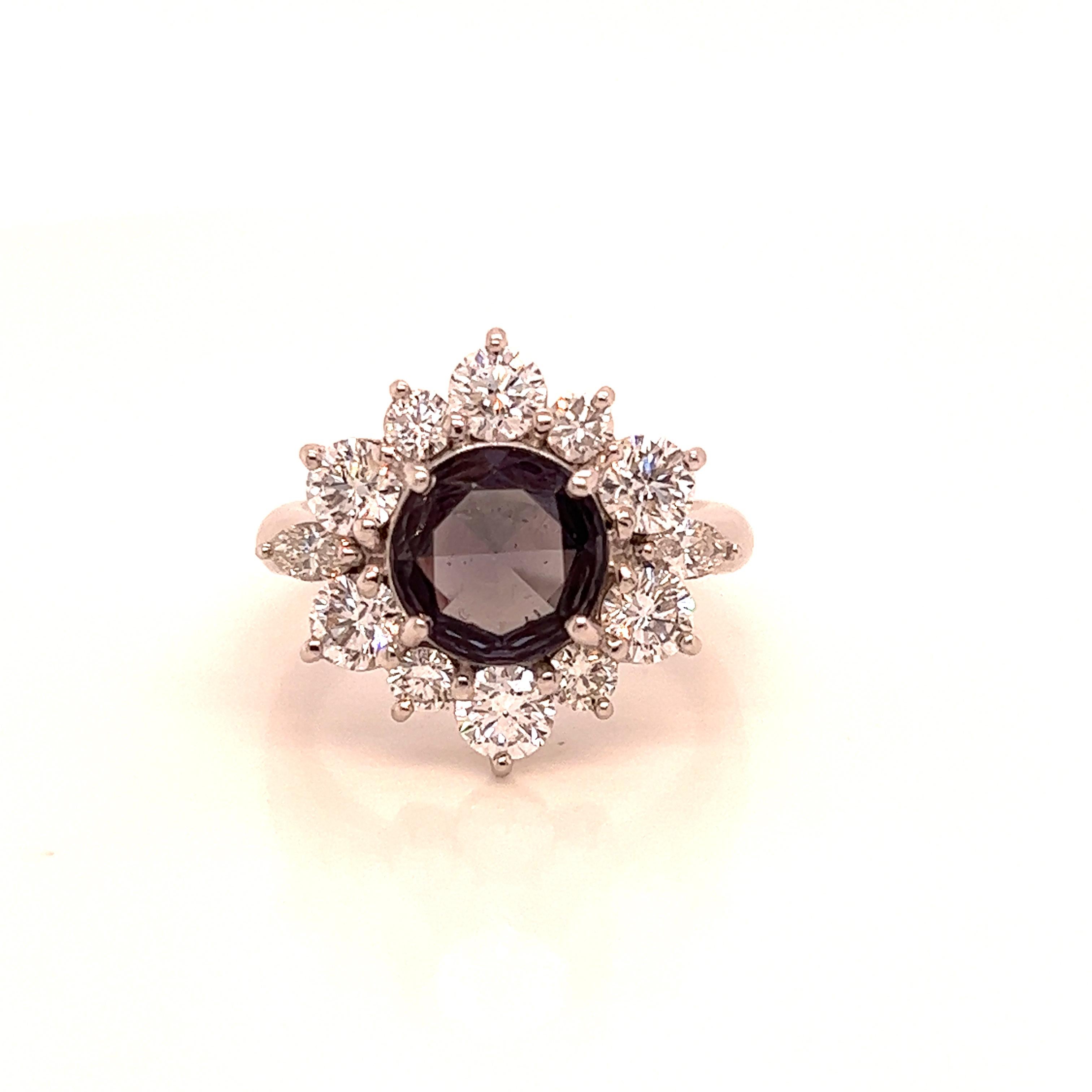 This is a gorgeous natural AAA quality round Alexandrite surrounded by dainty diamonds that is set in a vintage platinum setting. This ring features a natural 1.78 carat round alexandrite that is certified by the Gemological Institute of America