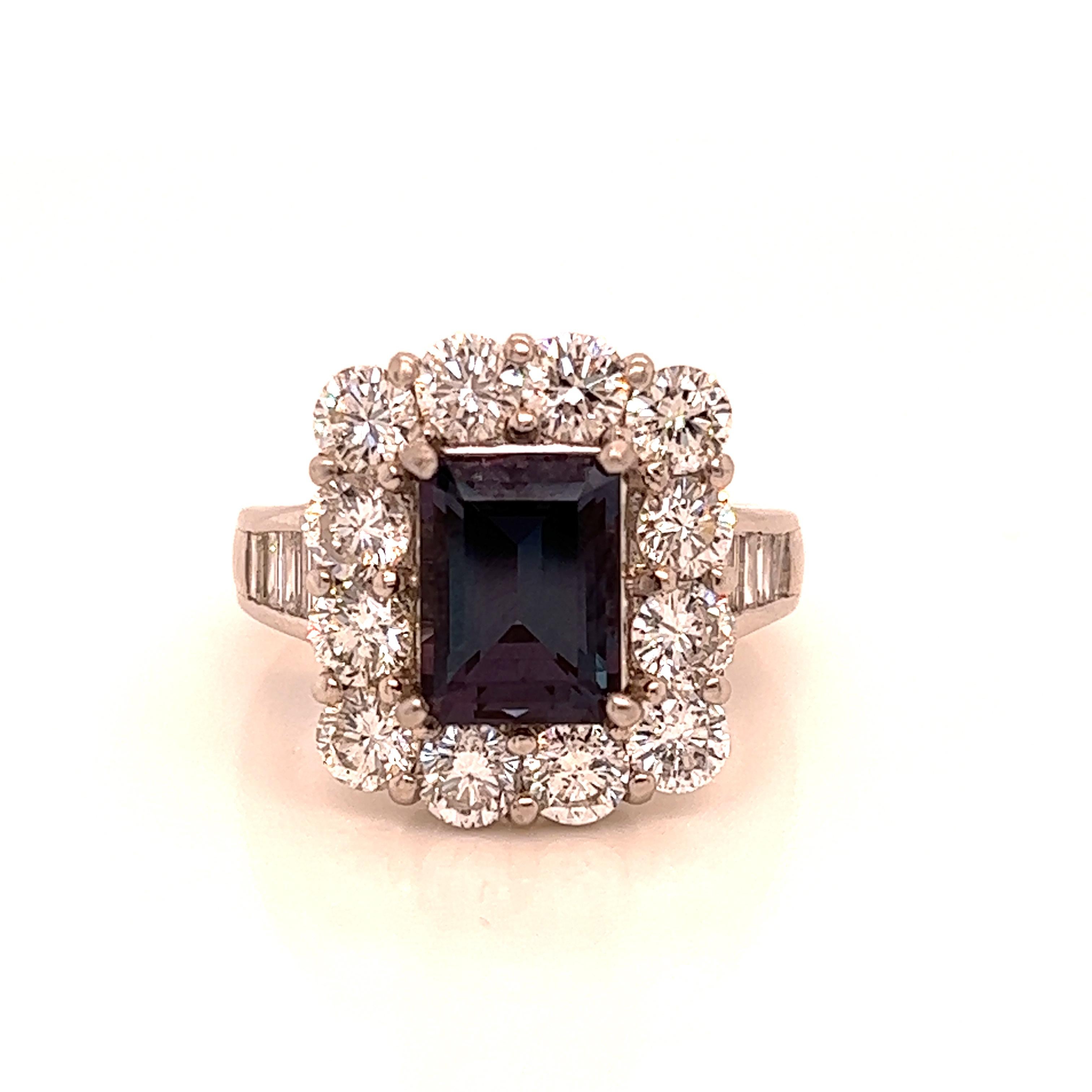This is a gorgeous natural AAA quality Emerald Alexandrite surrounded by dainty diamonds that is set in a vintage platinum setting. This ring features a natural 2.57 carat Emerald alexandrite that is certified by the Gemological Institute of America